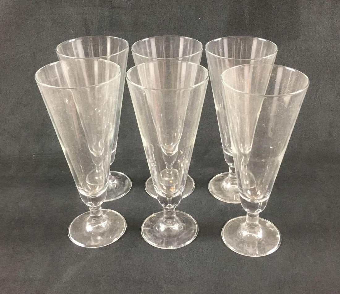 6 Clear Footed Pilsner Glasses: 6 Clear Footed Pilsner Glasses. These pilsner glasses are in good condition. They are pretty dirty and will need to be cleaned to remove residue. The glass not chipped or cracked. Each glass measures