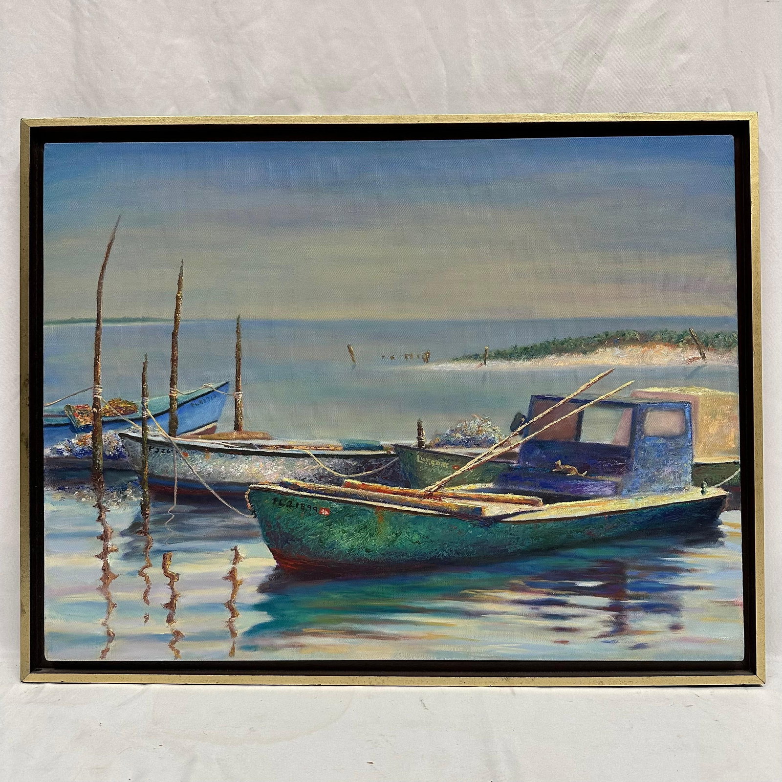 Original Coastal Fishing Boats Oil Painting on Canvas Signed: Original oil painting depicting weathered fishing boats along a calm shoreline. The artist's signature appears on the hull of one vessel, reading Lurgon (or a similar variation). Unknown Artist. T