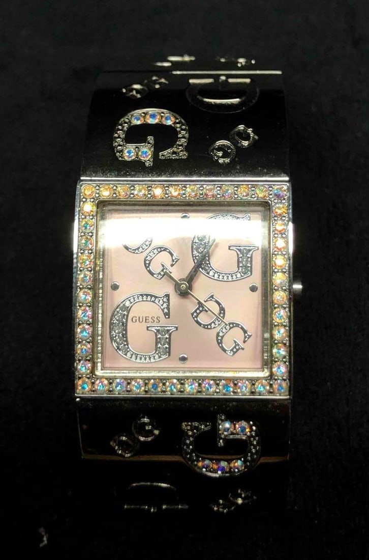Authentic Guess Pink Face Stainless Steel Watch G86136L: This lot contains an authentic pink face Guess silver tone stainless steel watch G86136L. The watch was made in China and is water resistant for up to 100 meters or 330 feet. It is approx 2 3/4" x 1"