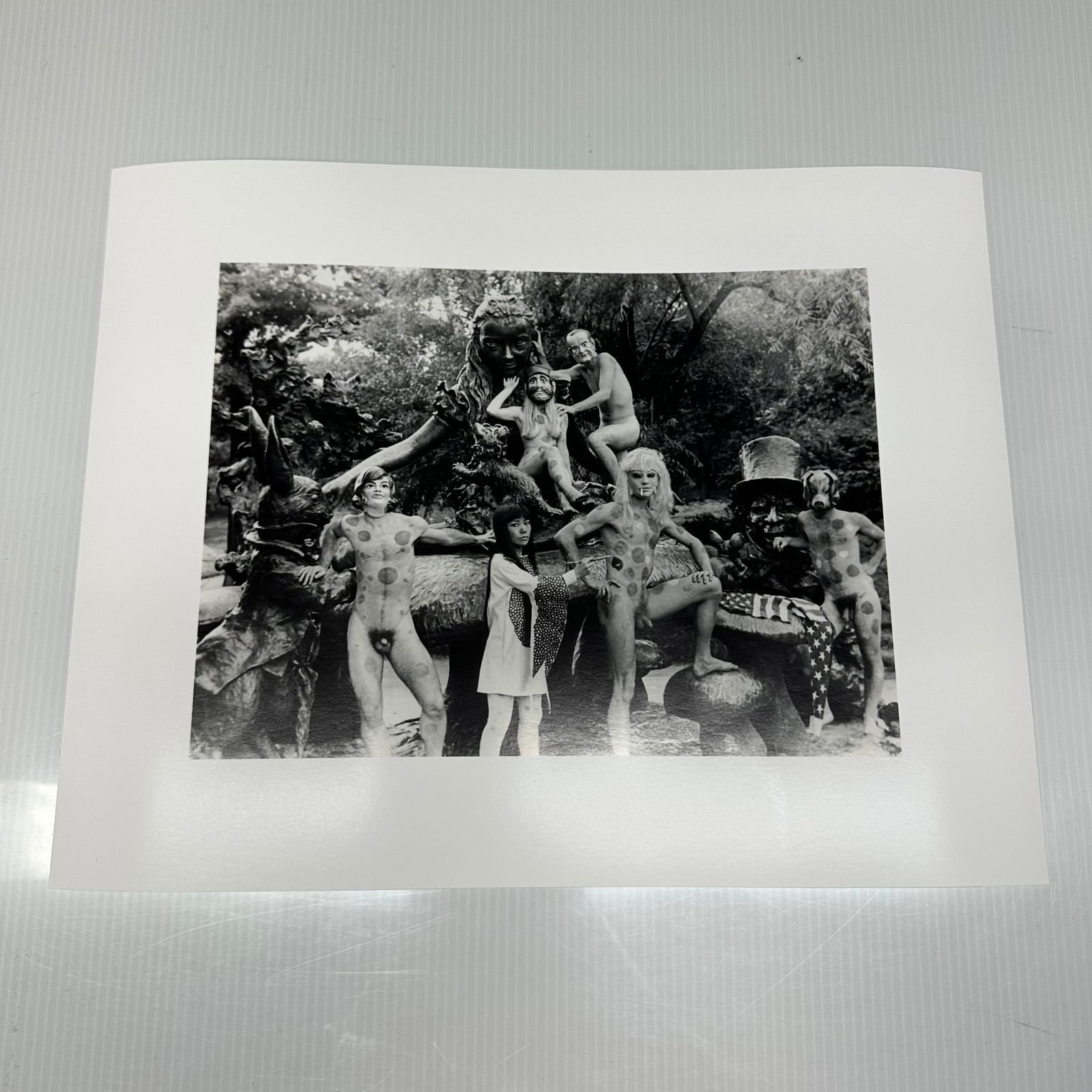 Yayoi Kusama Black and White Photo Print Nude Anatomic Explosion Happening: Black and white photographic print depicting Yayoi Kusama posed with polka-dotted nude models in an outdoor sculptural statue, Alice in Wonderland, setting in New York's Central Park.