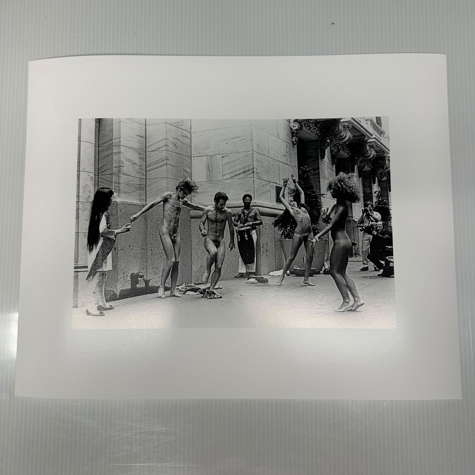 Yayoi Kusama Body Festival Black and White Photo Print: Black and white photographic print depicting Yayoi Kusama’s nude performance happening (Body Festival) outside a New York City building, circa late 1960s. The image shows dancers and onlookers