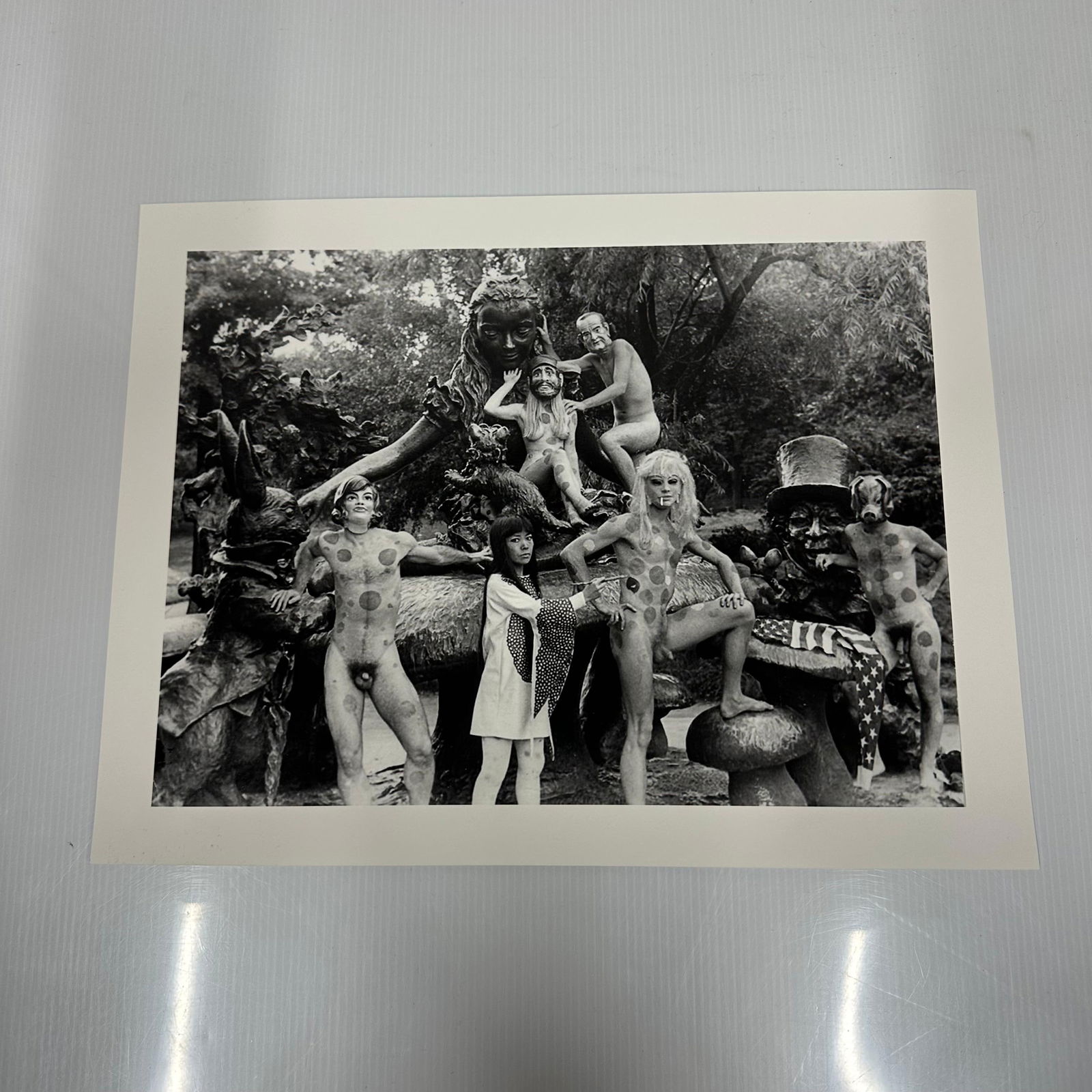 Alice In Wonderland Statue Yayoi Kusama Black and White Medium Photo Print NY Setting: Medium black and white photographic print depicting Yayoi Kusama posed with polka-dotted nude models in an outdoor sculptural statue, Alice in Wonderland, setting in New York's Central Park. Print