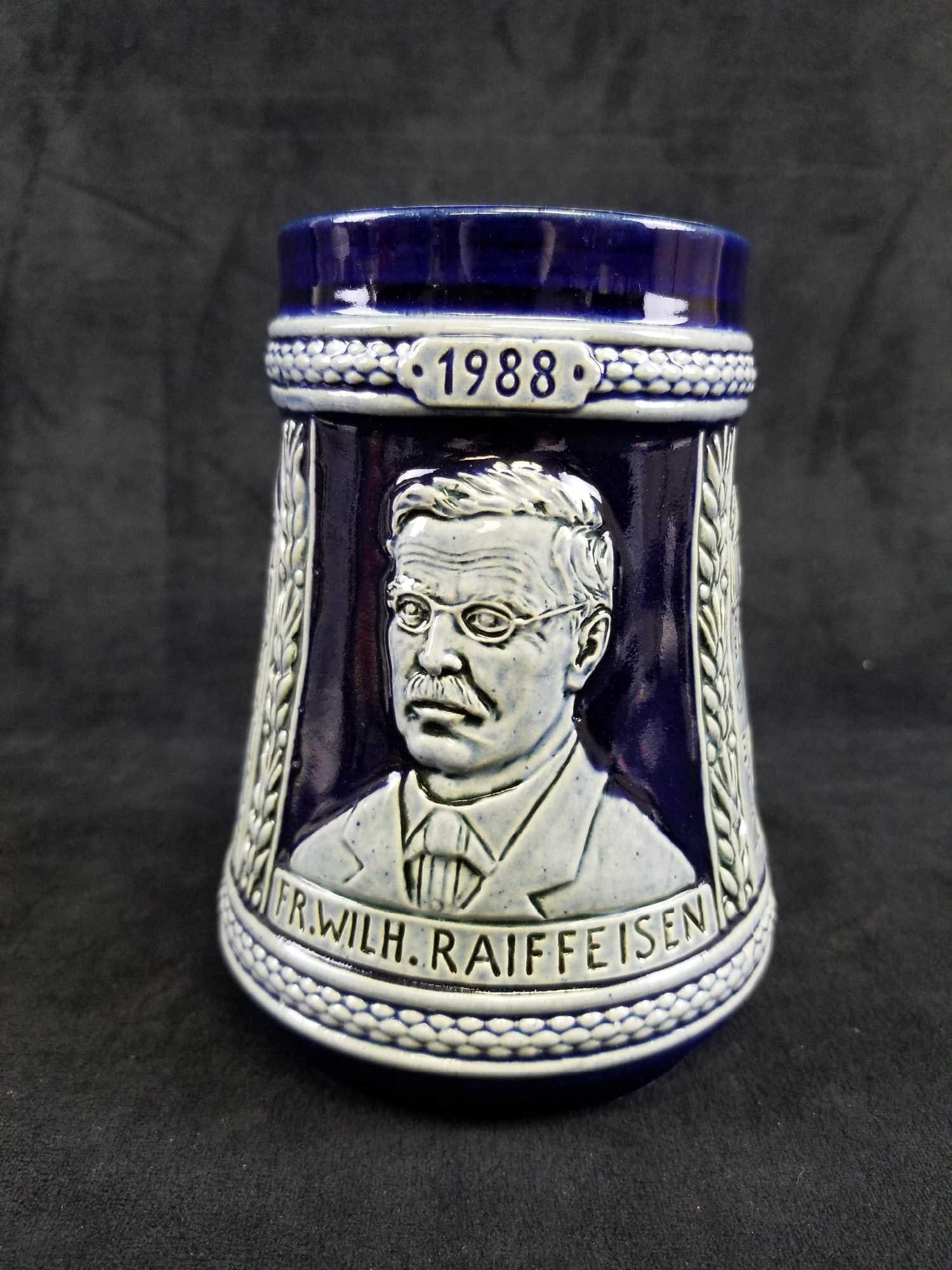 1988 Friedrich Wilhelm Raiffeisen Commemorative Beer Stein: This Stein is a Friedrich Wilhelm Raiffeisen Commemorative. In translation, the side reads "One for all, all for one". This stein stands at 6" tall and finished in pastel and cobalt blue in