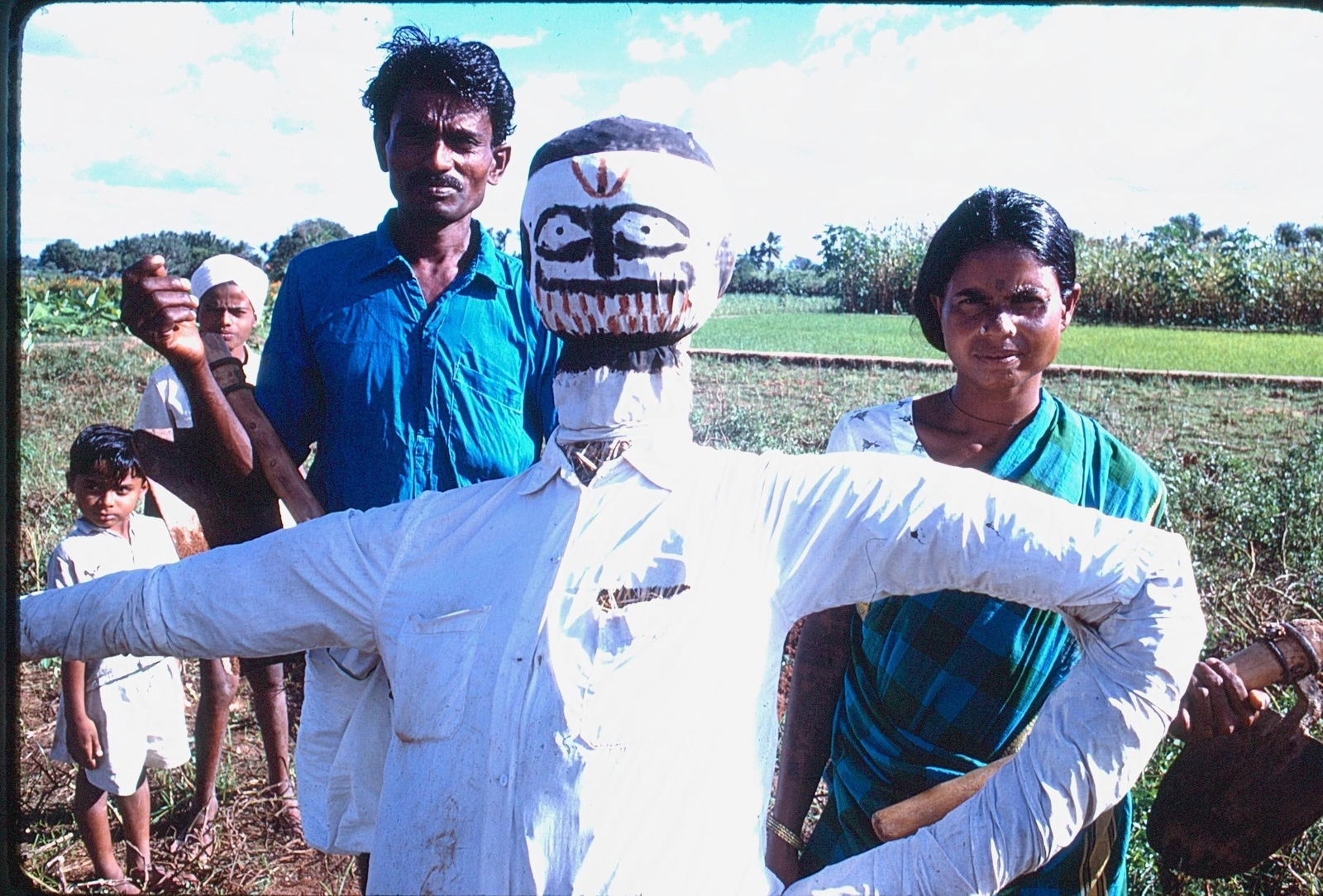 Kodachrome Photo Slide and Digital Prints Family with Handcrafted Scarecrow in Field: Original Kodachrome photograph slide and digital prints depicting a rural family in a field with a handcrafted scarecrow figure dressed in a white shirt. Vivid scene showing traditional farming life
