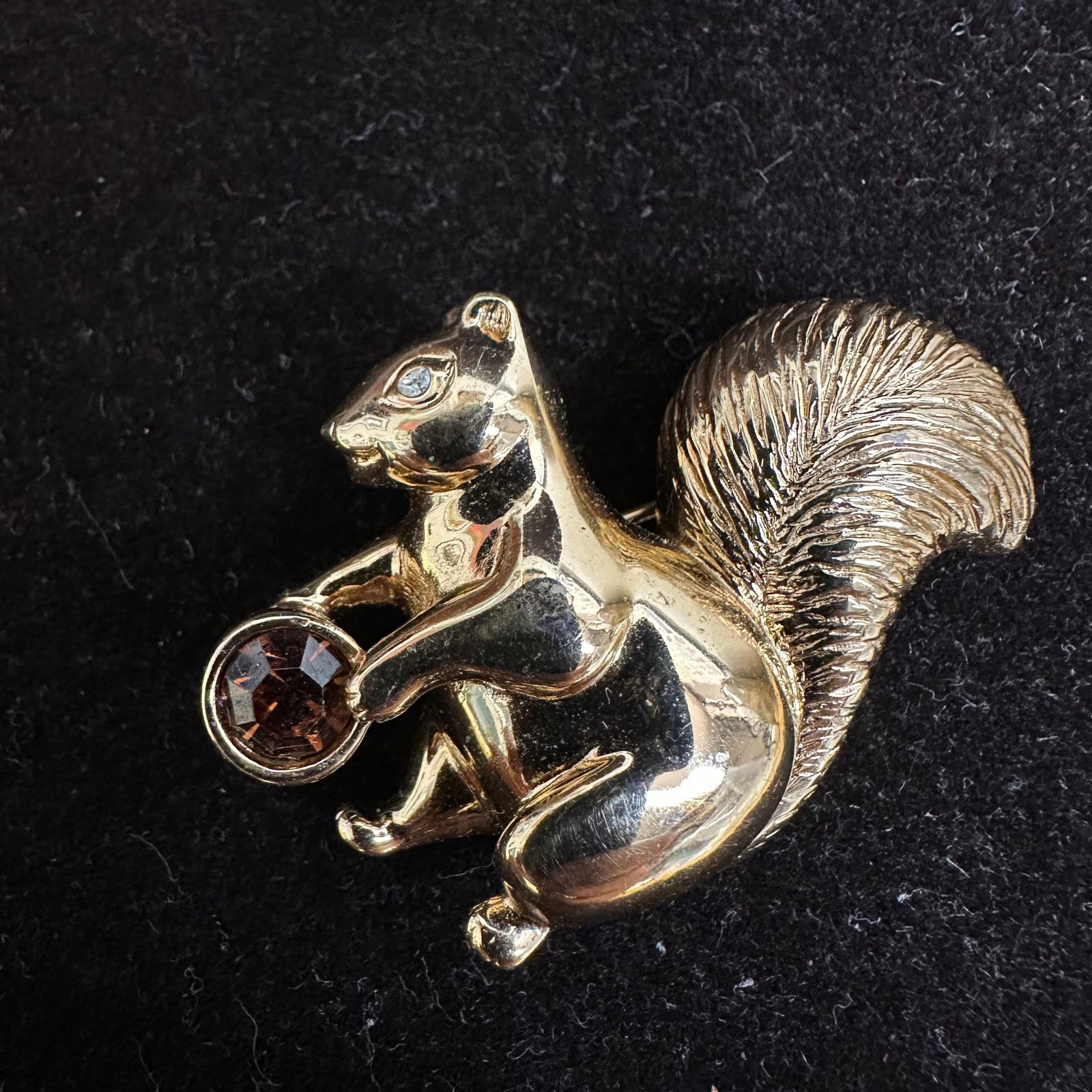 Swarovski Squirrel Crystal Brooch Fall Colors Brown Clear Gold Tone: Swan Swarovski hallmark brooch features brown and clear Swarovski crystals and gold-toned accents. This item is in good pre-owned, previously displayed condition with light wear and surface scratches.