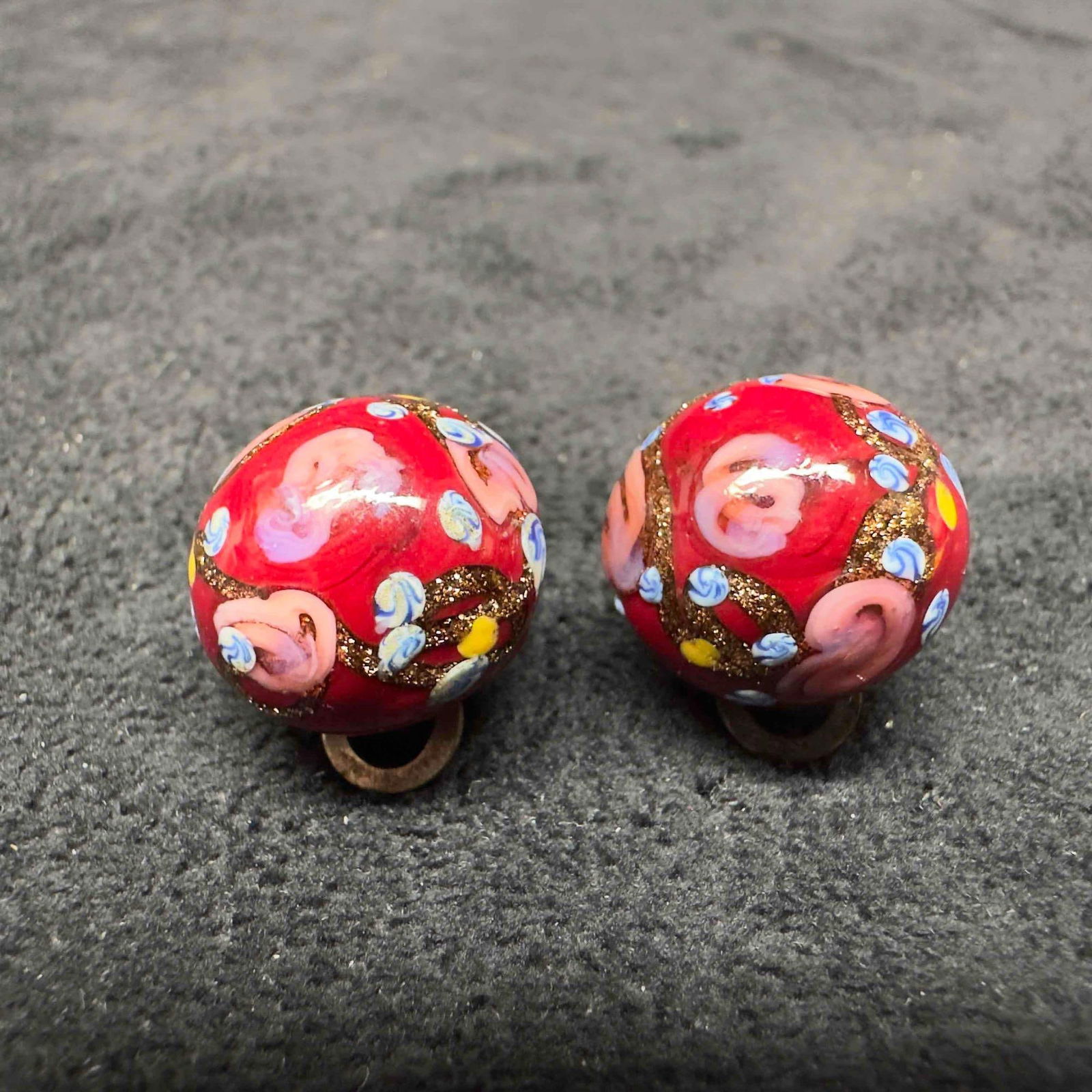 Murano Venetian Art Glass Lamp Work Red Round Floral Beaded Earrings D53: Murano Venetian Art Glass Lamp Work Red Round Floral Beaded Earrings D53. Earrings with red glass beads with beautiful designs on each. The earrings feature floral accents. The earrings feature a padd