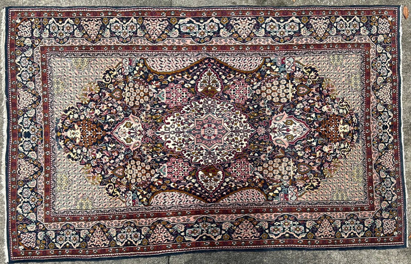 Hand-Knotted Persian Rug with Floral Medallion Design: Hand-knotted Persian wool rug featuring an intricate central floral medallion with repeating garden motifs throughout. The rug displays a rich palette of burgundy, navy blue, cream, and rose, framed b