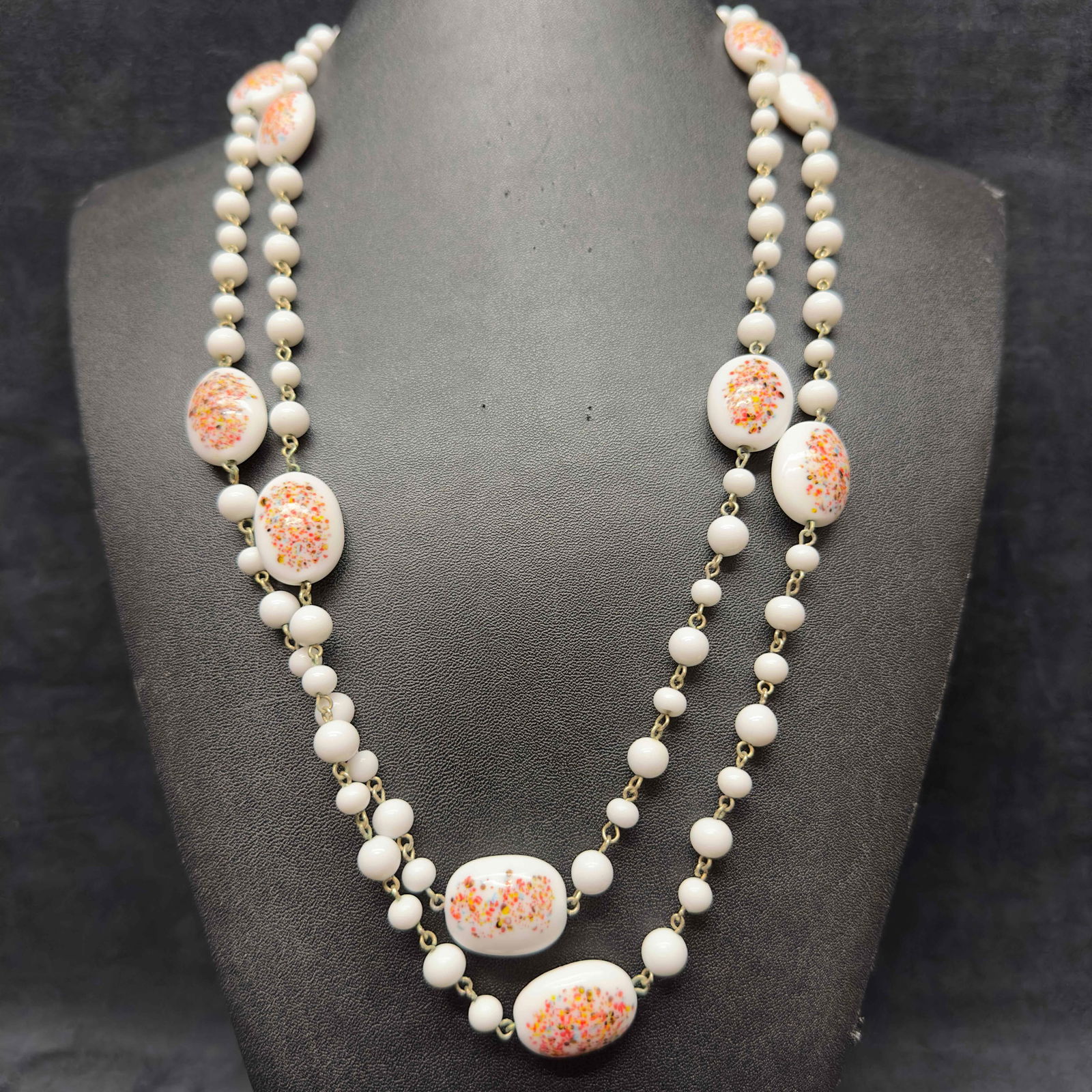 White Milk Glass Art Beaded Multi Colored Accents Costume Jewelry Long Necklace H10: White Milk Glass Art Beaded Multi Colored Accents Costume Jewelry Long Necklace H10. Necklace with white colored glass beads with beautiful designs on each. The necklace features multi colored accents