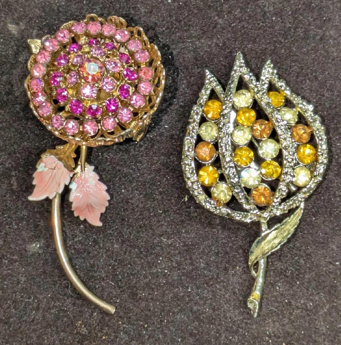 Two Vintage Rhinestone Flower Brooches: Two Vintage Rhinestone Flower Brooches. This lot includes: (1) Gold Toned Yellow Flower Brooch With Yellow/Amber Rhinestones. This is approx 1 3/8"x 1/2" x 2 1/2".(1) Pink Rhinestone