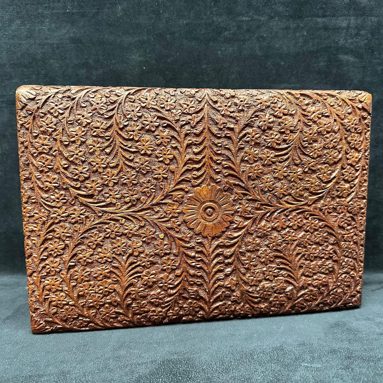Hand Carved Floral Wooden Box with Velvet Interior Highly Detailed Style: Vintage, highly detailed style hand-carved wooden box featuring intricate floral and foliate relief patterns on all sides. Interior lined with orange velvet felt fabric. Hinged lid opens smoothly;