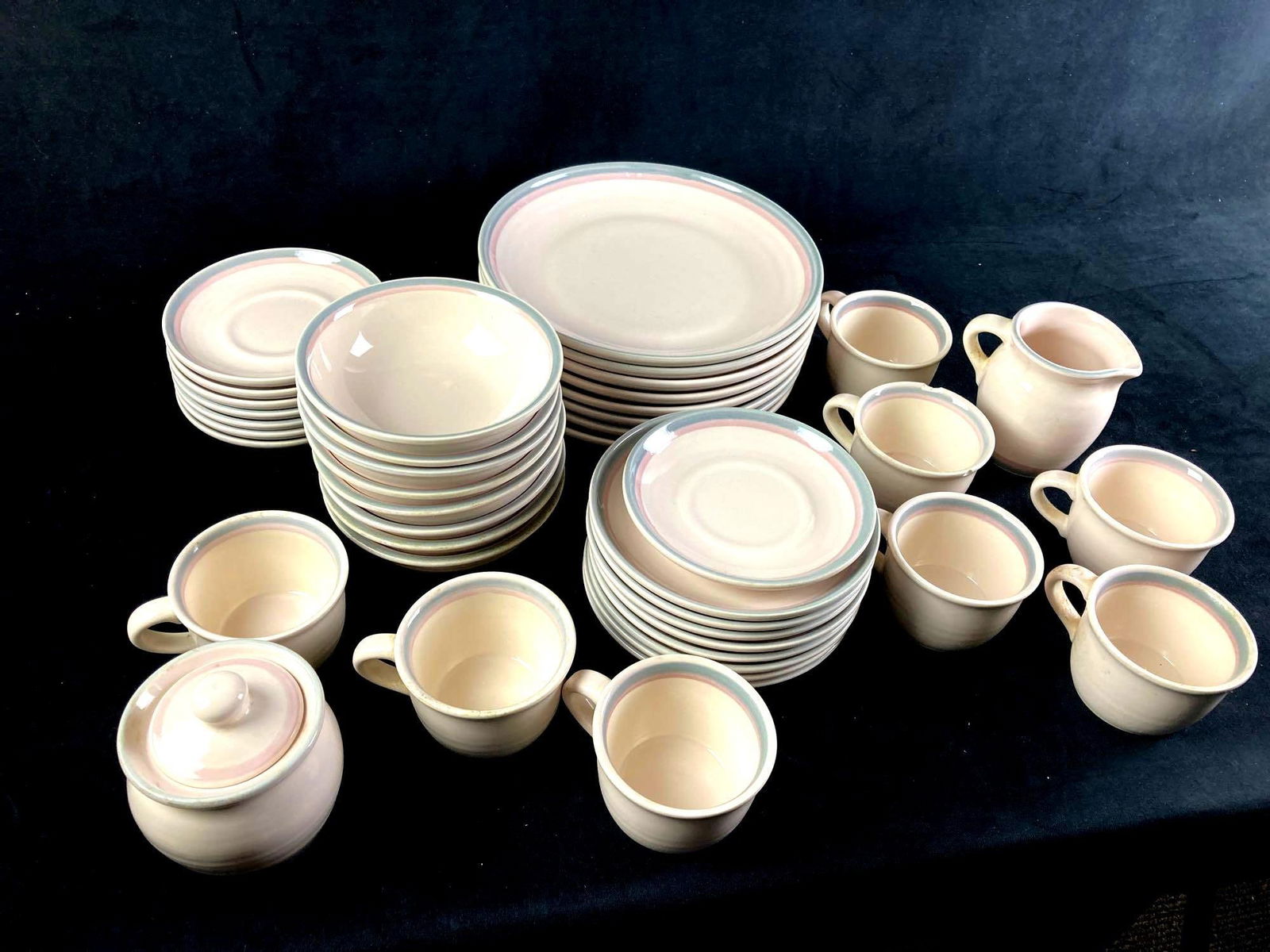 Pfaltzgraff Juniper Dinnerware Set: Pfaltzgraff Juniper Dinnerware set fresh from recent estate. Contains plates, bowls, cups, and small dining accoutrements. All white in color with blue and red rings around the tops. This auction
