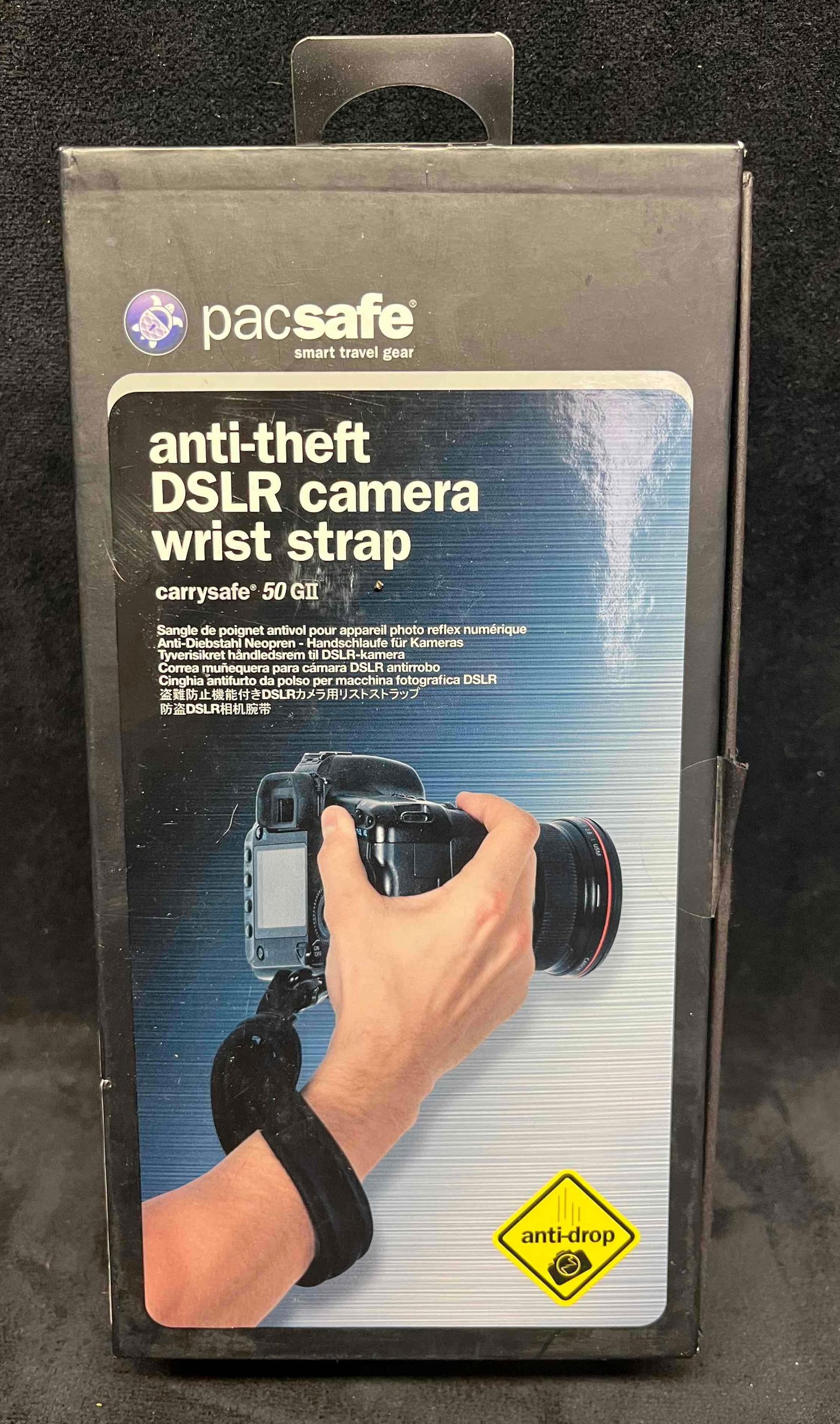 PacSafe Anti-Theft DSLR Camera Wrist Strap In Original Box (2): This lot contains a PacSafe Anti-Theft DSLR Camera Wrist Strap In Original Box (2). The box is approx 4 1/2" x 2 1/4". Total weight is 0.6lbs. Overall the camera strap is in good condition as it does