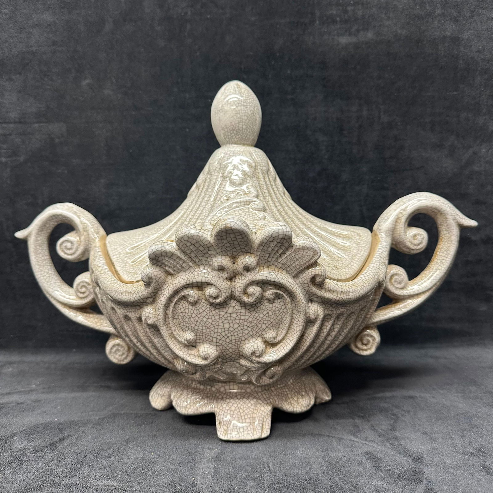 Ornate Crackle Glaze Ceramic Covered Dish with Handles: Decorative ceramic covered dish featuring an ornate rococo-style design with scrolling handles and raised floral detailing. Finished in a neutral crackle glaze throughout. Includes a matching lid