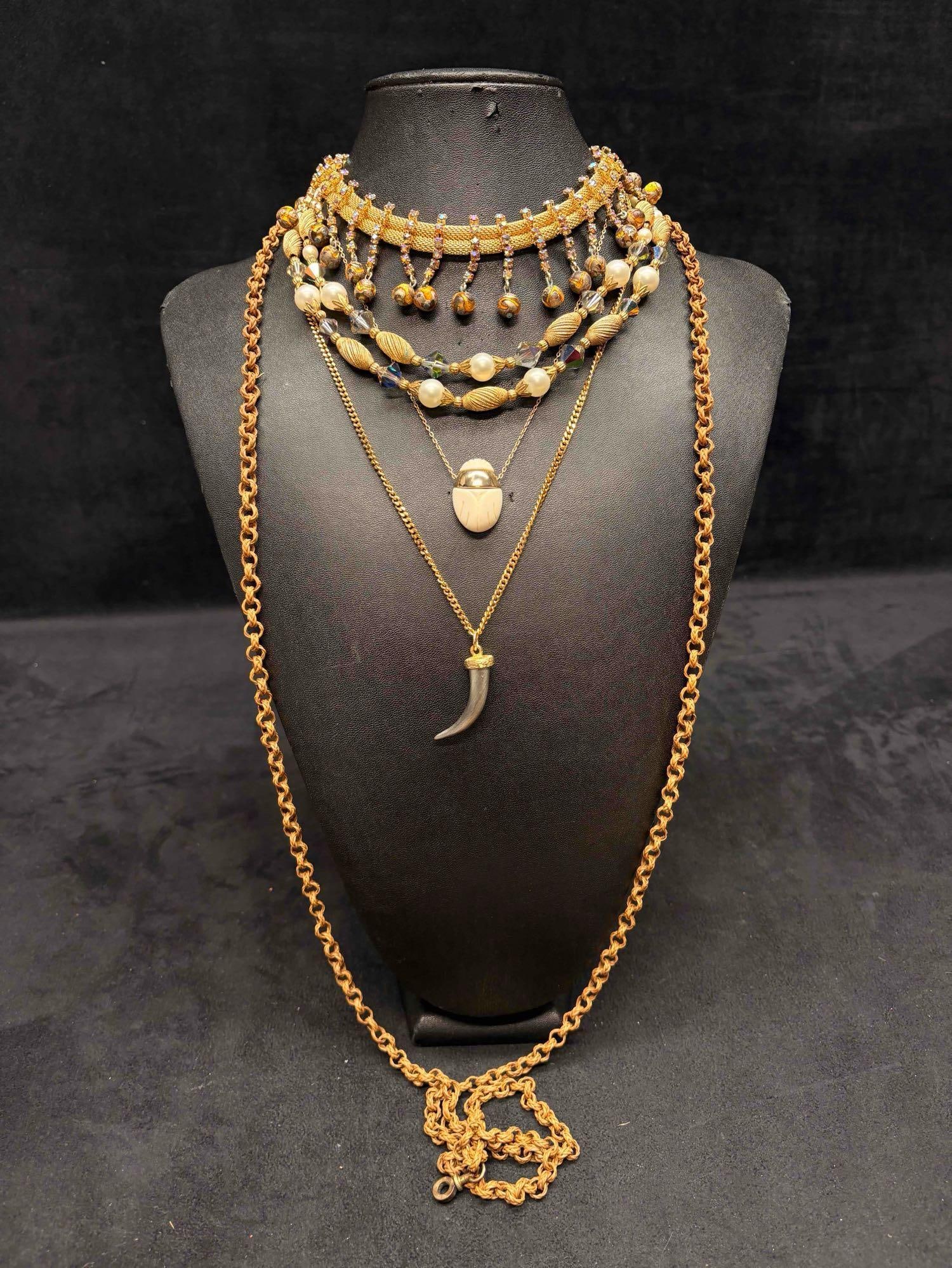 5pc Gold Jungle Themed Necklace Lot: This lot consists of 5 pre-owned costume jewelry necklaces with typical wear from use. Please review images for context of the lots visual conditions. APPROX. WEIGHT: 4.4 OZ