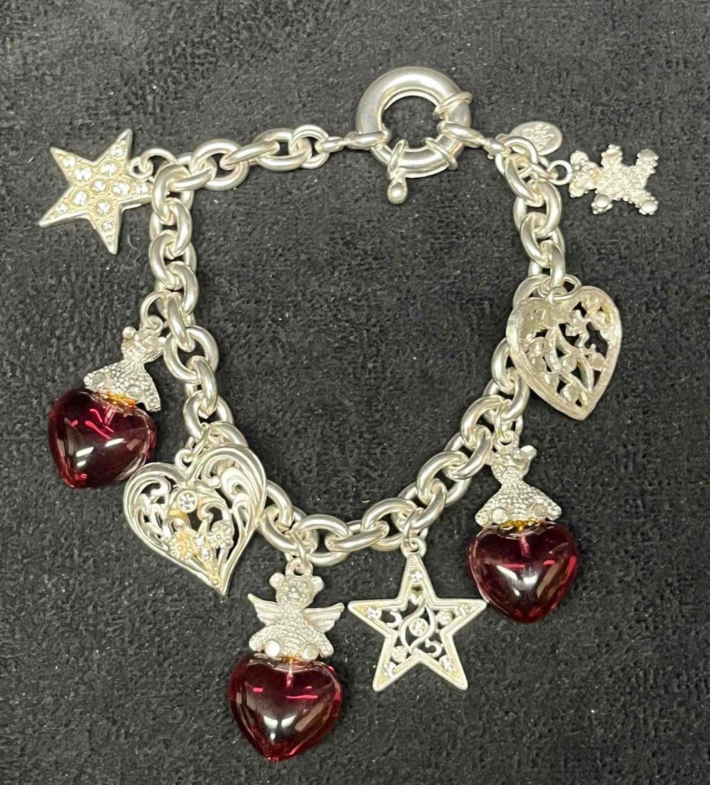 Signed Vintage Kirks Folly Silver Tone Heart Star And Cherub Charm Bracelet: This lot contains a Signed Vintage Kirks Folly Silver Tone Heart Star & Cherub Charm Bracelet. The Kirks Folly brand was established in 1979 in New York. The bracelet is approx 8 1/2" long unclasped.&