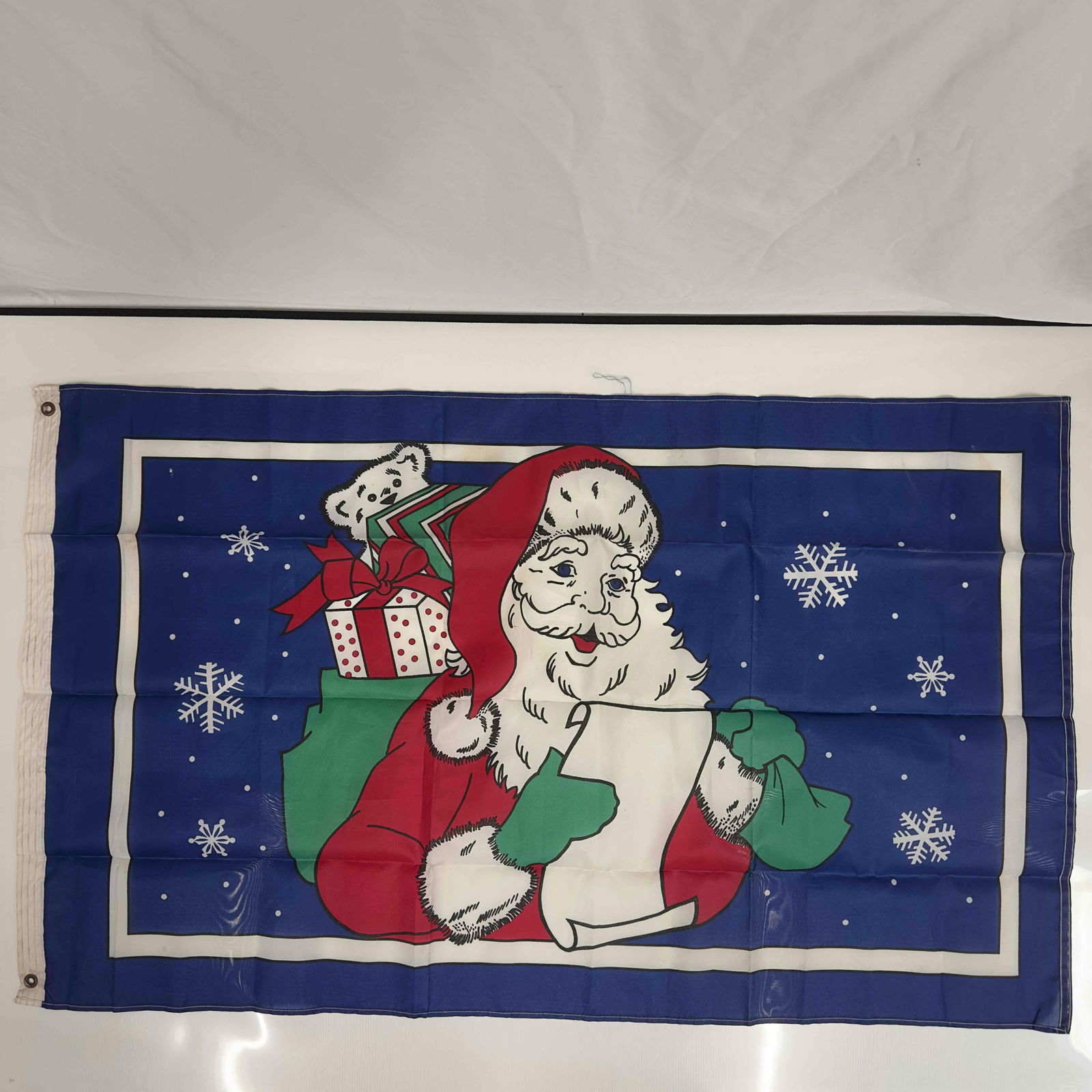 Vintage Christmas Santa Blue Holiday Flag: Vintage Christmas Santa Blue Holiday Flag. Light loose threading and a few minor stains, overall good condition for age. This item is in pre-owned, previously displayed condition with light wear, and
