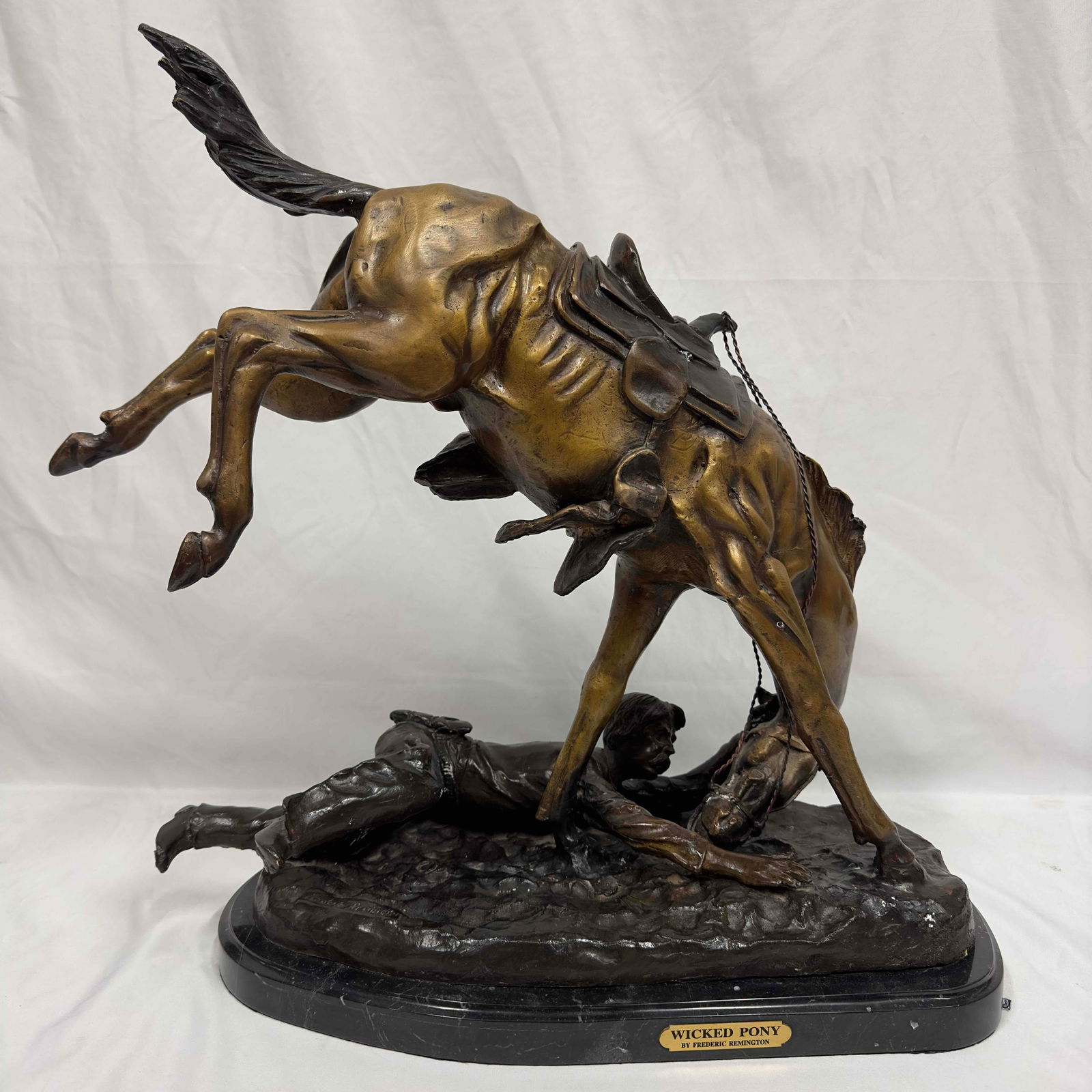 Wicked Pony By Frederic Remington Hand Made Real Bronze Art Sculpture Large Jumbo Figure: This dynamic large bronze sculpture depicts a cowboy thrown from his horse. This bronze statue has a black marble base and Frederic Remington etched into the bottom bronze base portion. Statue is a li