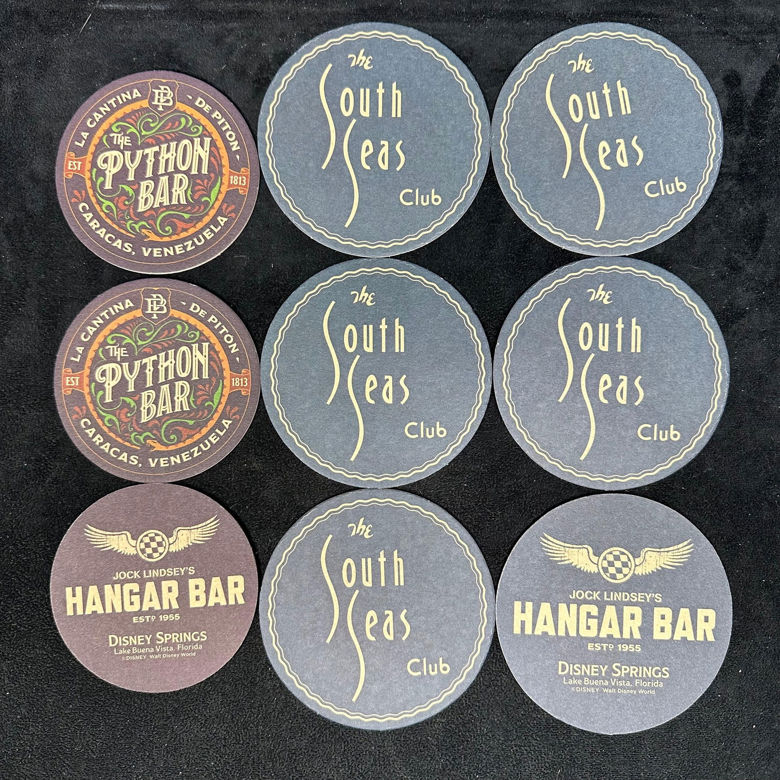 Disney Springs Jock Lindsey's hangar Bar Coaster Set of Nine Python and South Seas: Mixed lot of bar drink coasters from Jock Lindsey’s Hangar Bar, Disney Springs, Lake Buena Vista, Florida, featuring designs from The South Seas Club and The Python Bar. Coasters are round and