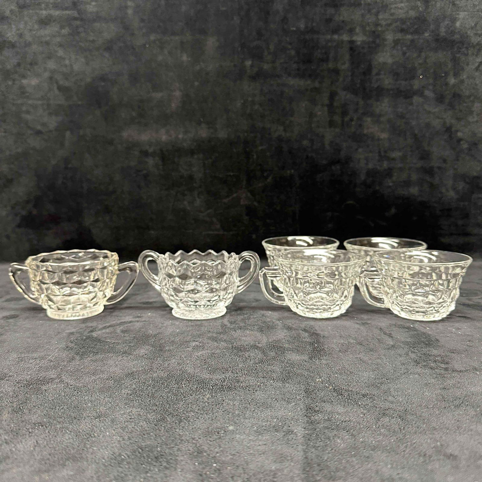 Fostoria American Cubist Pattern Design Creamer Sugar and Glass Cup Set: Six Fostoria glass pieces included in this set, including four glass cups, one creamer cup with dual handles and one sugar glass cup with dual handles. No noticeable chips, cracks, or breaks in the gl