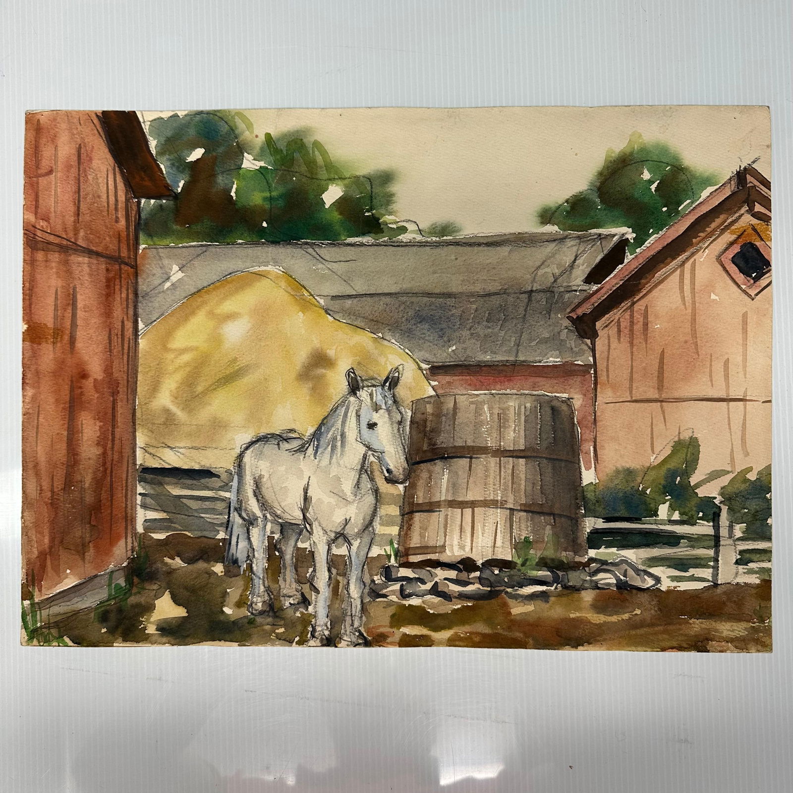 Original Watercolor Farm Scene with White Horse and Barns: Original watercolor painting on paper depicting a rural farmyard scene with a white horse standing near a wooden barrel, haystack, and barns. Executed in watercolor with ink outlining. Reverse