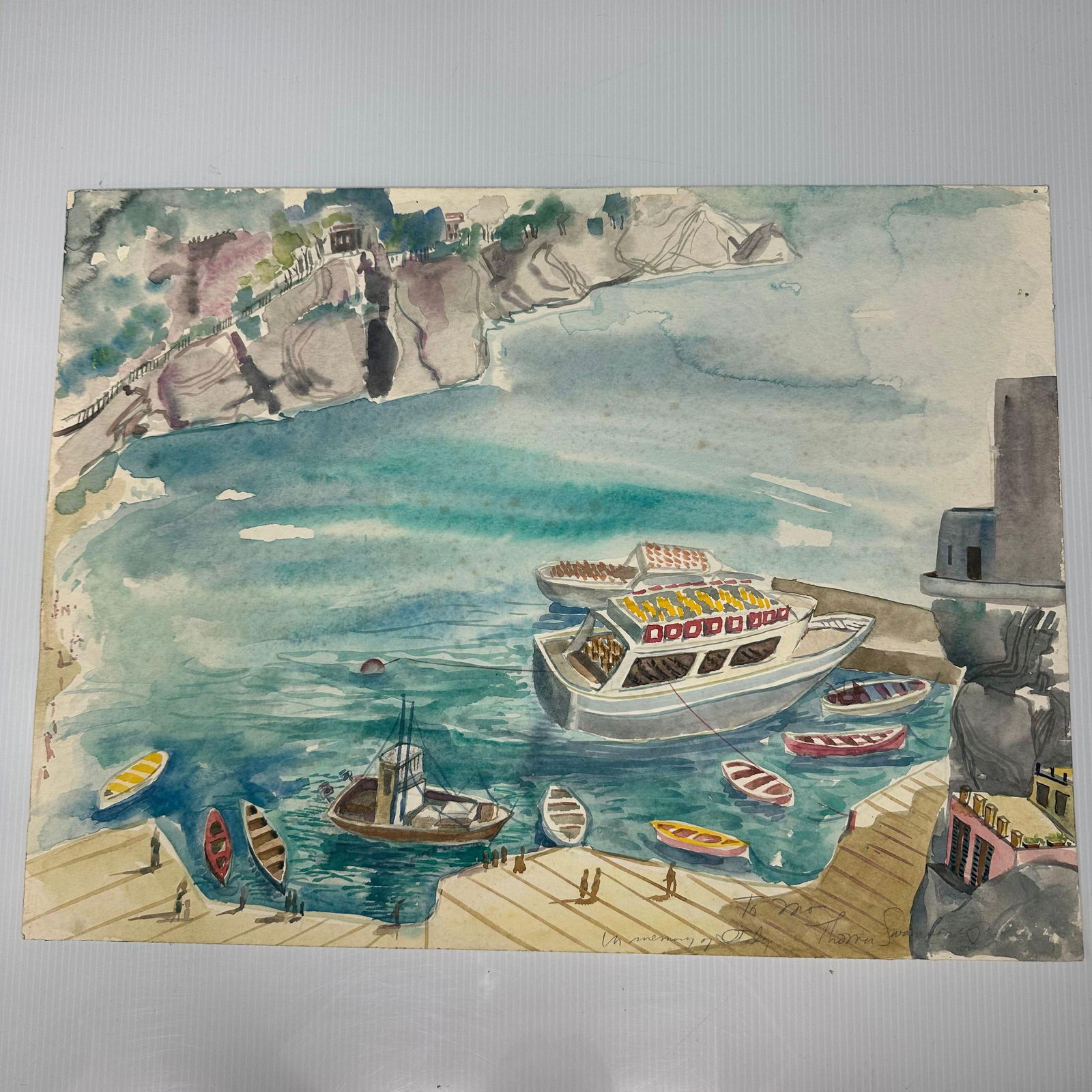 Harbor Scene Watercolor Painting with Boats and Coastal Cliffs: Original watercolor painting depicting a harbor scene with a passenger boat docked near a pier, small rowboats in the water, and coastal cliffs with buildings in the background. Signed lower right