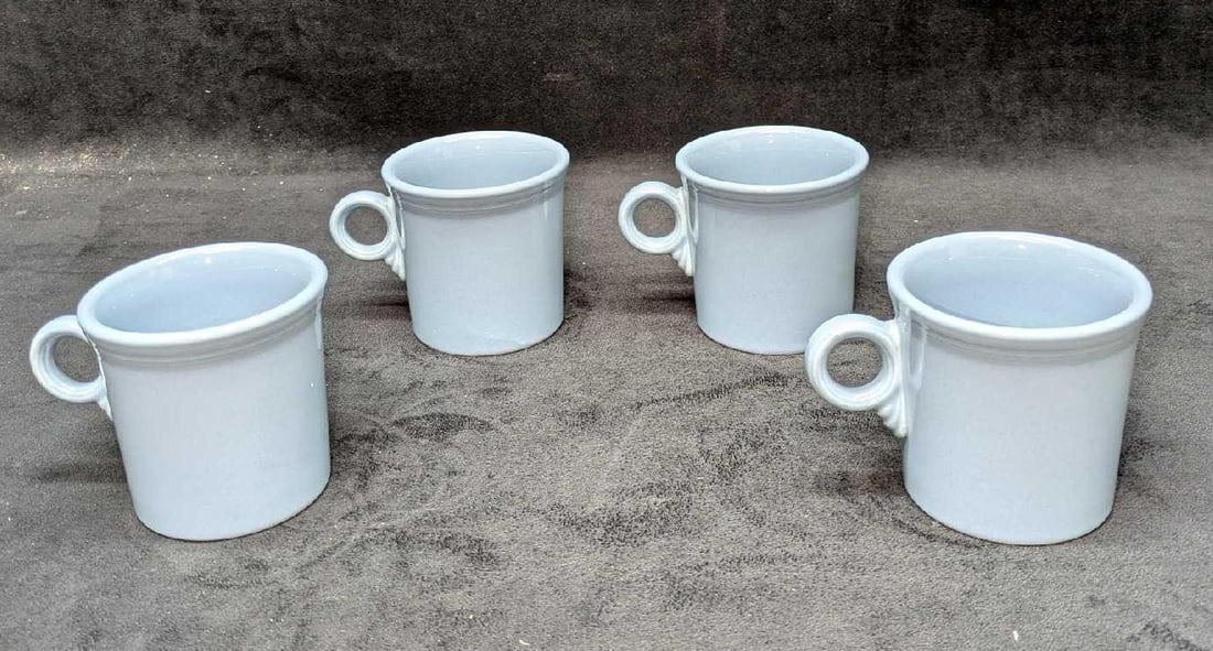 4 Fiesta Periwinkle Blue Mugs B: 4 Fiesta Periwinkle Blue Mugs B. Each is approx 5" x 3 1/2" x 3 3/8" and the total weight is 3.94 lbs. The bottom of the mugs are marked, but the markings are very light.