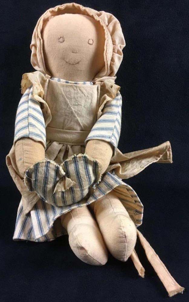 Handmade Folk Art Cloth Heart Doll: Handmade Folk Art Cloth Heart Doll. This doll is in fair condition. The doll has a good amount of discoloration. The doll is holding a heart and wearing a hat and striped dress. The doll is approx 8"