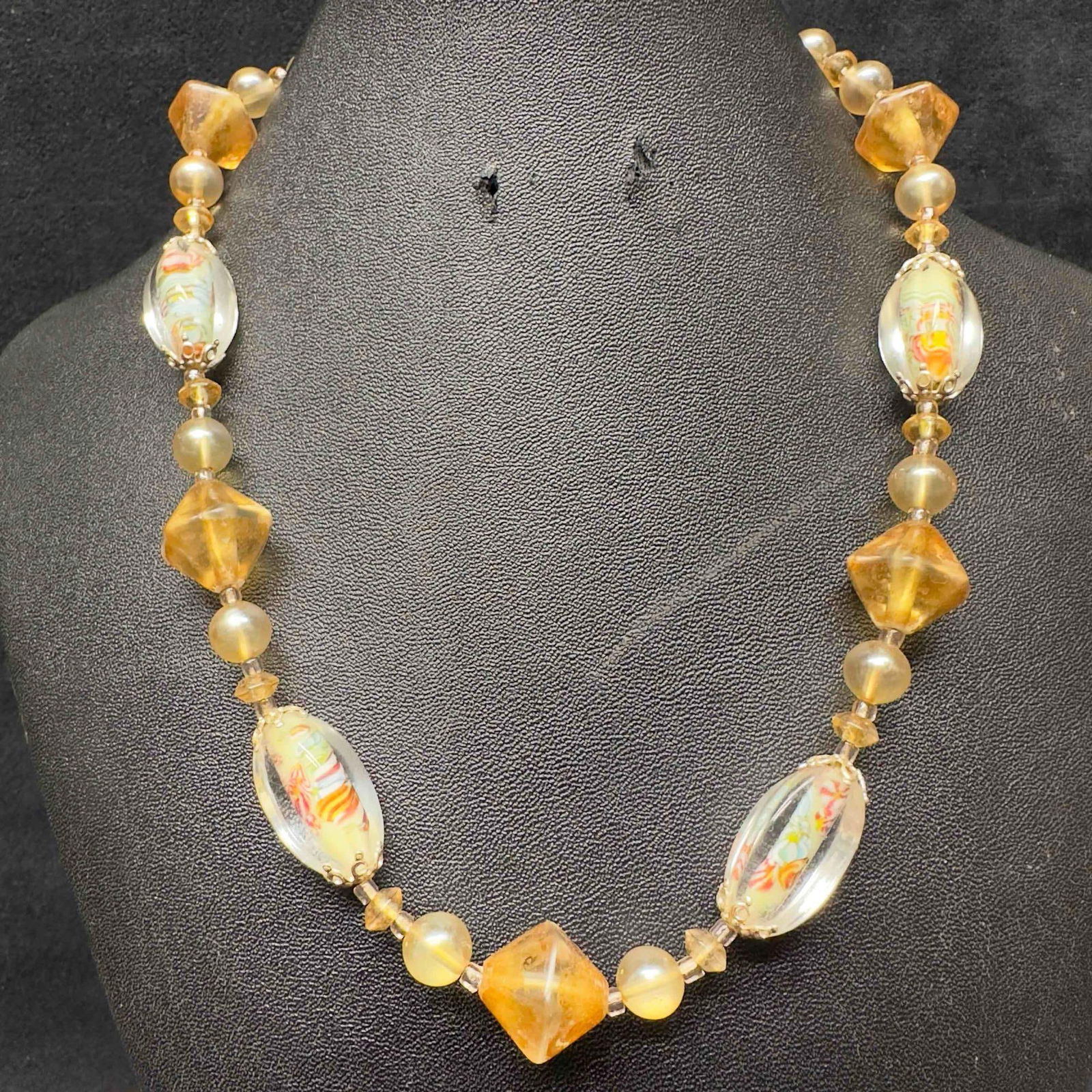 Murano Venetian Lamp Work Art Glass Clear Tan Multi Colored Beaded Necklace F96: Murano Venetian Lamp Work Art Glass Clear Tan Multi Colored Beaded Necklace F96. Necklace with clear multi colored glass beads with beautiful designs on each. The necklace features red and blue