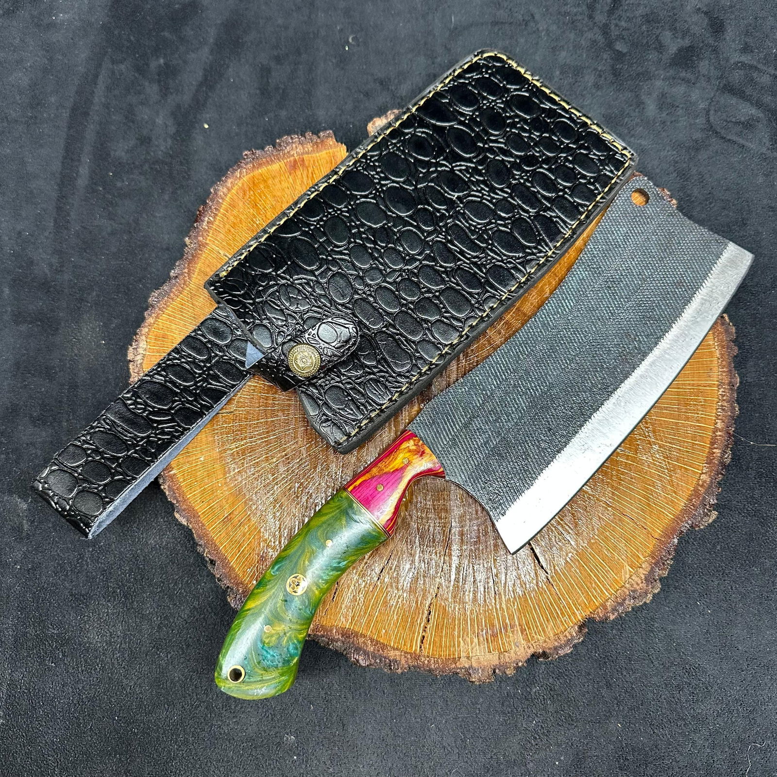 Large MHS Cutlery Cleaver Knife with Textured Blade Red Orange Handle Q35: A large MHS Cutlery fixed-blade cleaver knife featuring a textured steel blade and a multi-colored handle with layered wood and epoxy resin style accents. Includes fitted black leather sheath with emb