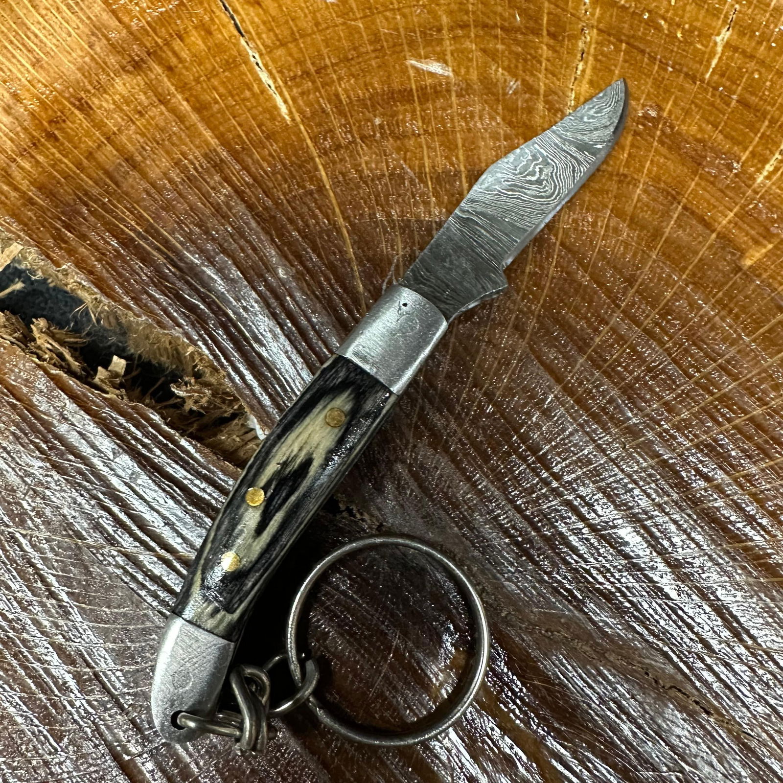 MHS Cutlery Keychain Steel Folding Blade Pocket Knife R55 Black: Small folding-blade pocket knife featuring a steel blade and a compact epoxy-resin/wood black colored handle secured with brass pins. Includes an attached metal key ring for easy carry. Good