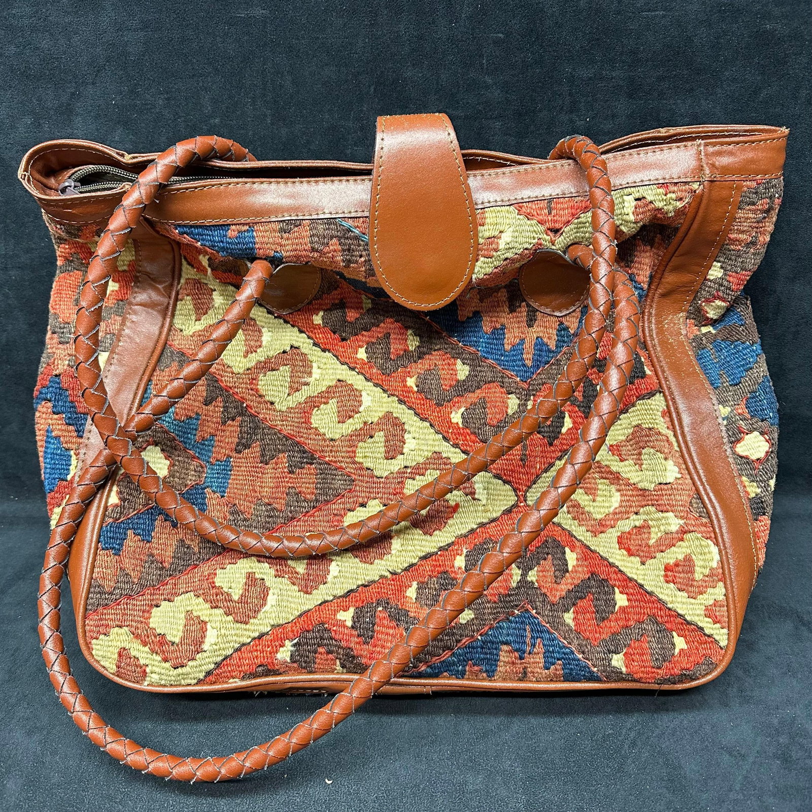 Handwoven Kilim Wool and Brown Leather Tote Bag Anatolian Art: Handcrafted tote featuring a multicolor geometric kilim wool textile body with brown leather trim throughout. Includes braided leather shoulder handles, leather top tab closure, and a structured leath