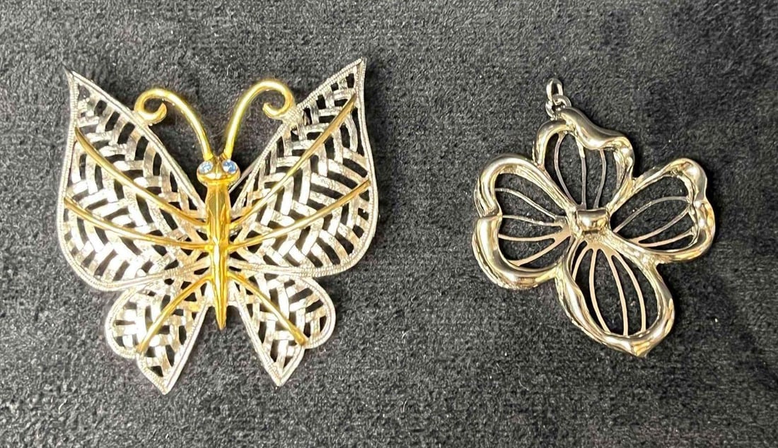 Avon Silver Tone Flower Pendant & Butterfly Brooch: This lot contains a Avon Silver Tone Flower Pendant & Butterfly Brooch. The butterfly brooch is approx 2" x 1 3/4" x 1/2" while the flower pendant is approx 1 3/4" x 1 1/2" x 1/4". Total weight i