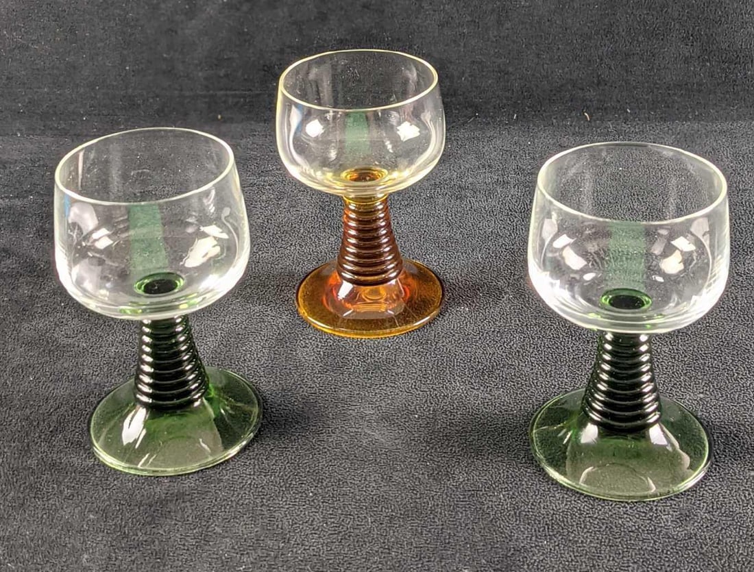 3 Vintage Ribbed Stem Wine Green & Amber Glasses: Three Vintage Ribbed Stem Wine Green & Amber Glasses. The maker and date of creation are unknown. Each glass is approx 2 1/2" x 2 1/2" x 4 1/4" and together they all weigh 1.09lb. The glasses are in a
