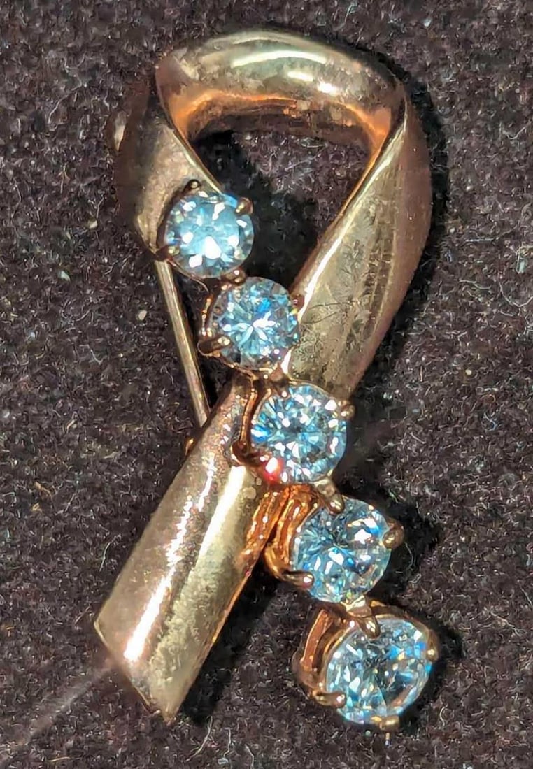 Kenneth Jay Lane Breast Cancer Awareness Pin: Kenneth Jay Lane Breast Cancer Awareness Pin. The pin/brooch is goldtone with five round cubic zirconia stones. This is approx 1/2" x 1/2" x 1 3/8". It comes in a bag that is approx 2" x