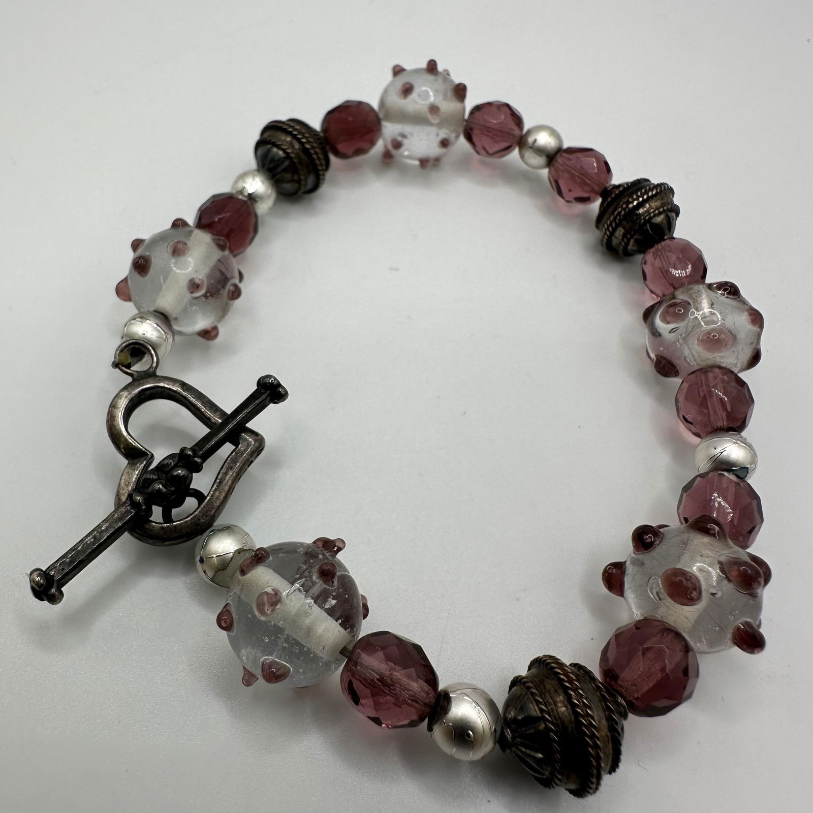Purple Clear Art Glass Beaded Sterling Silver Accent Bracelet Heart Clasp: This item is in good pre-owned, previously used/displayed condition with noticeable light wear and surface scratches. Please reference all photos for full details. This piece of jewelry has been teste