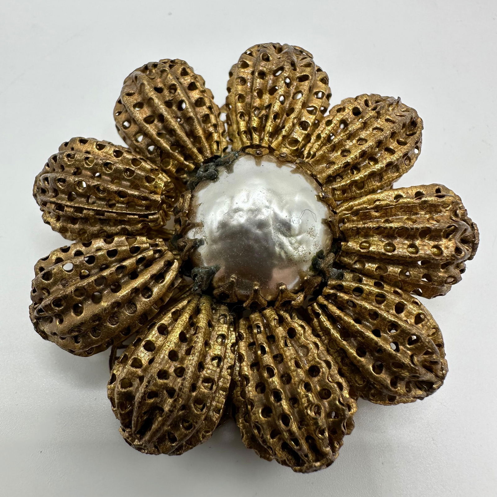 Miriam Haskell Large Gold Tone Floral Brooch with Flower Baroque Style Silver Tone Center: Vintage Miriam Haskell statement brooch featuring an ornate floral design with layered gold-tone filigree petals surrounding a large baroque-style silver-tone center. The petals are textured with open