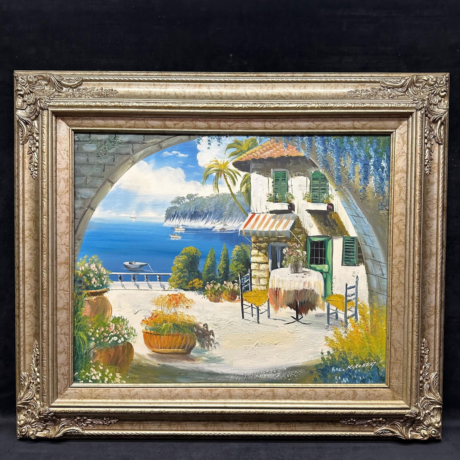 K. Robert Signed Original Oil Painting Mediterranean Villa Terrace by the Sea Framed: Original oil painting on canvas signed K. Robert, depicting a bright Mediterranean terrace overlooking a serene coastal view. The composition shows a sunlit villa with green shutters, flowering plante