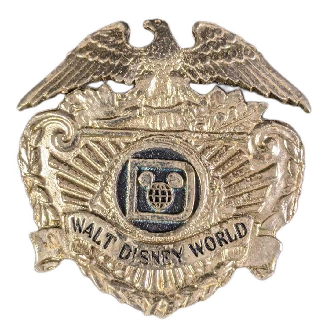 Vintage 1970s Walt Disney World Security Badge: Vintage 1970s Walt Disney World Security Metal Badge. Is approx 2 1/2" x 2/1" and weighs under one pound at 0.07lb. The badge is in a good, vintage condition with some wear. Looks to have been a hat b