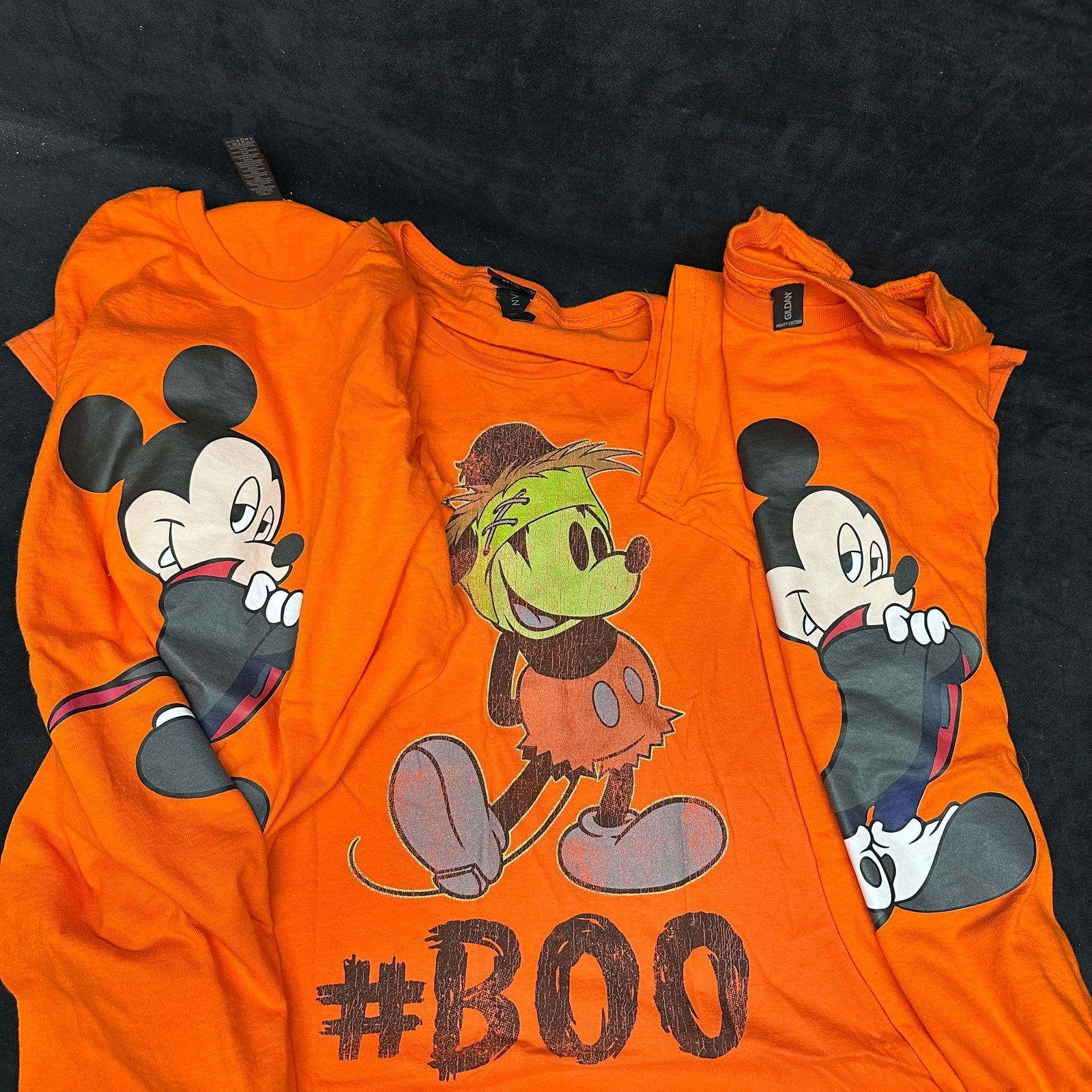 Three Disney Mickey Mouse Halloween T-Shirts Orange Medium: A lot of three Disney Mickey Mouse holiday Medium T-shirts featuring a spooky Halloween design. These items are in pre-owned, previously displayed condition with light wear and surface markings. Pleas