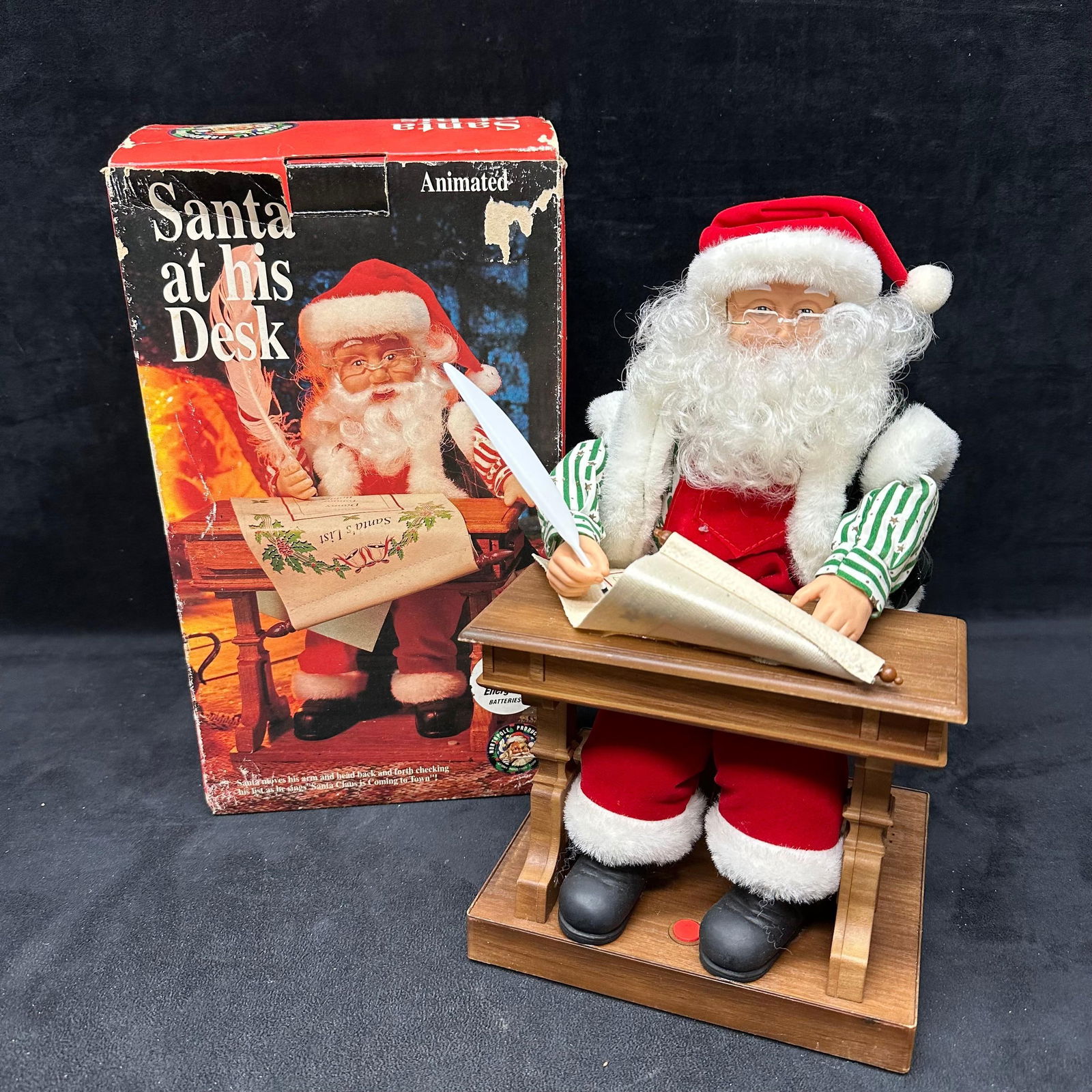 1994 Gemmy Animated Santa At His Desk Making A List: 1994 Gemmy animated Santa figure seated at his desk, writing on his list with moving arm and head. Comes with original box (showing notable wear). Battery-operated; untested for functionality. Santa