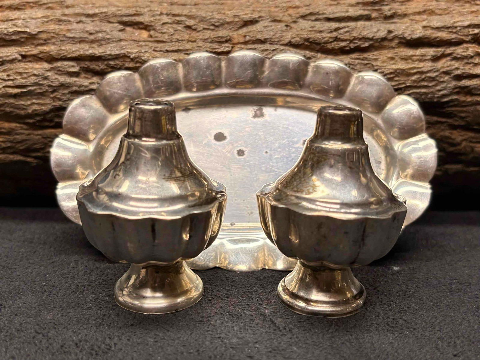 3pc 1970s Mexican 925 Sterling Silver Salt Shakers and Trays: This lot containers a salt and pepper shaker, displaying ornate Mexican motifs and ribbed bodies. The base of the shakers unscrew, allowing it to be refilled. Due to age, the grooves and nooks of the