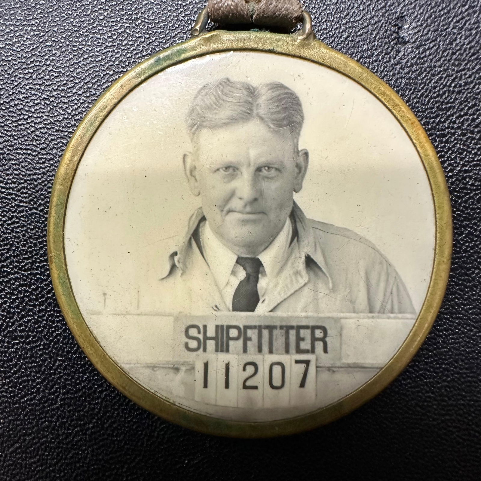 US Navy Yard Philadelphia PA ID Identification Badge World War Era Necklace: Original World War era U.S. Navy Yard, Philadelphia, PA, worker's identification badge featuring a photo portrait labeled, "Shipfitter 11207". Brass-encased badge with original cloth neck