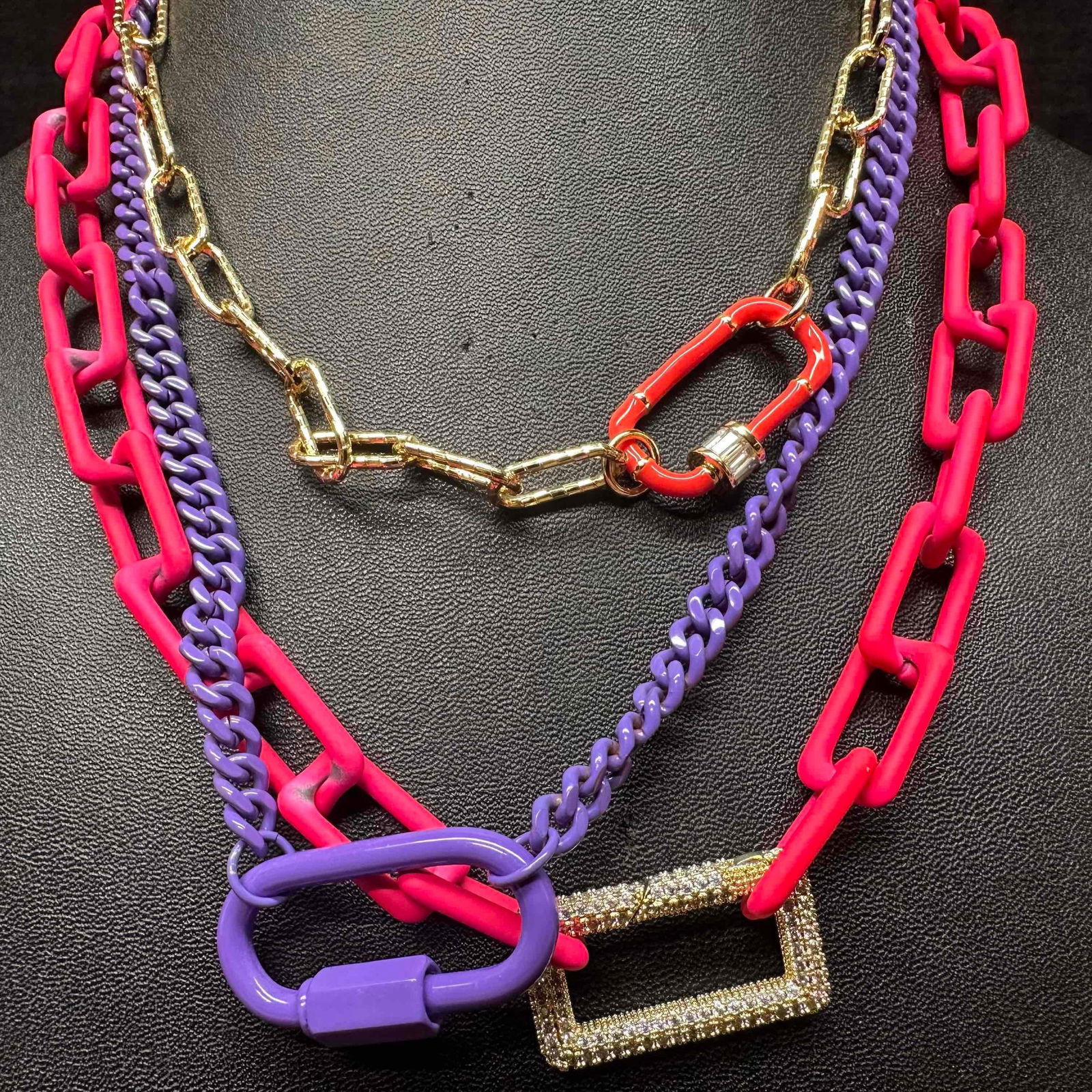 Melania Clara Assorted Necklace Purple Pink Gold Chain Set: The Melania Clara necklace set features a magnet clasp closure. The necklaces have magnet extender clasp closures. Each necklace showcase modernist designs with gold toned and rhinestone accents.