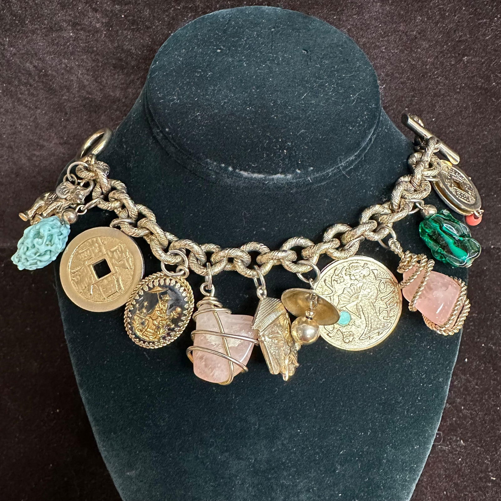 Gold Toned Chunky Colorful Asian Style Charm Rose Quartz Bracelet Q73: Heavy gold-tone charm bracelet featuring a textured chunky rope-link chain with toggle clasp. Bracelet is adorned with multiple dangling charms, including Asian-style coins with square centers, figura