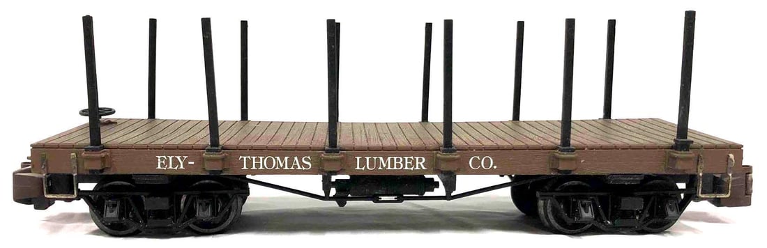 Ely Thomas Lumber Co. Toy Flatcar With Logs: This lot contains a Ely Thomas Lumber Co. toy flatcar with logs. This flatcar is made of high-impact plastic and has metal wheels. It is approx 13 1/2" x 4 1/2" x 3 3/4". The flatcar comes with 9 toy