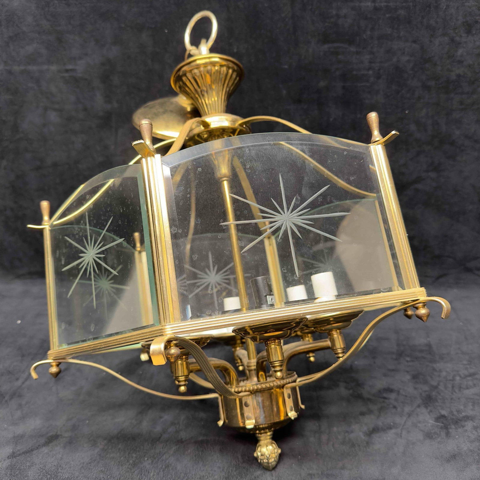 Underwriters Laboratories Gold Tone Glass Panel Leaf Sunburst Chandelier Six Lights Panels: Gold Tone Glass Panel Leaf Sunburst Chandelier Six Lights Panels. This beautiful gold toned chandelier features six lights and sunburst design glass panels. One white candle resemblance piece missing