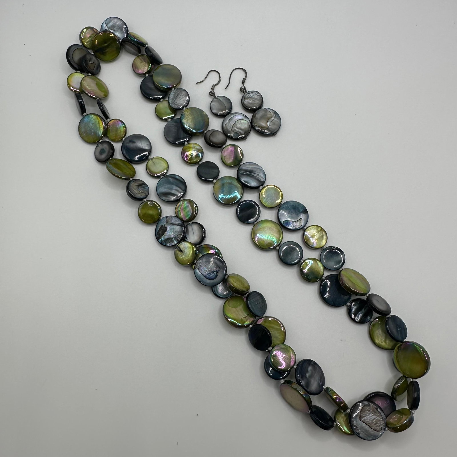 Iridescent Green Abalone Shell Coin Beads Necklace and Sterling Earrings Set: Vintage pair of 925 marked earrings with a matching necklace featuring iridescent green shimmering abalone shell coin beads. No other hallmarks are noticed. These items are in pre-owned, previously us
