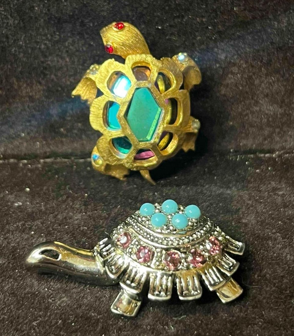 Two Intricate Turtle Brooches With Unique Rhinestones: This lot contains Two Intricate Turtle Brooches With Unique Rhinestones. The silver tone turtle is approx 1 1/2" x 1/2" x 1/2" and the gold tone turtle is approx 1 1/4" x 1" x 3/4". Total weight is