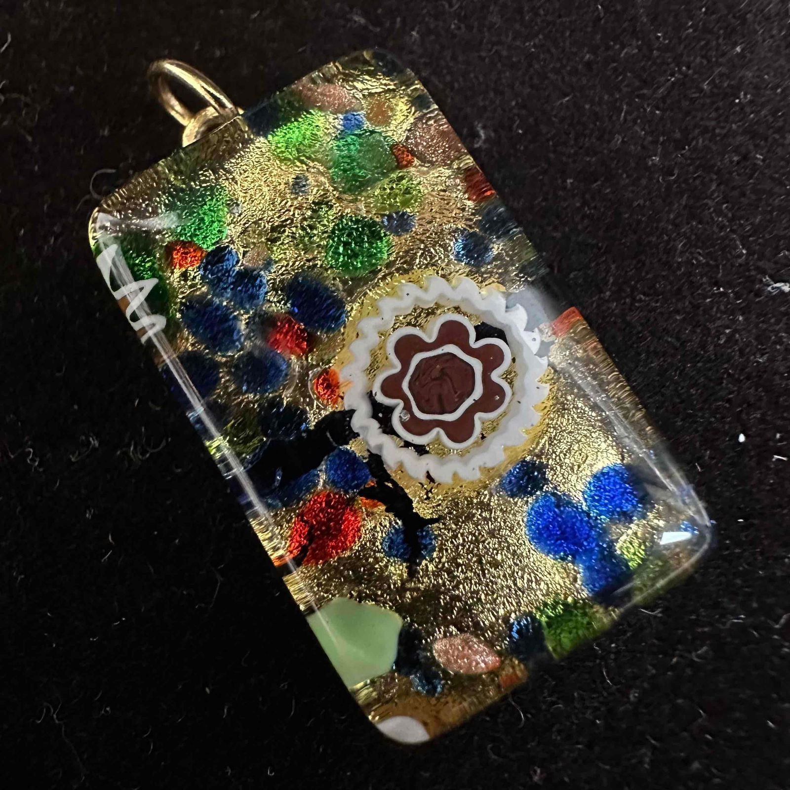 Murano Glass Millefiori Floral Multi Colored Gold Tone Pendant Flower Motif: Venetian Murano Lamp Work Art Glass Necklace Pendant. Pendant with gold and blue colored glass with beautiful hand crafted designs. The pendant features a flower motif and copper colored accents.