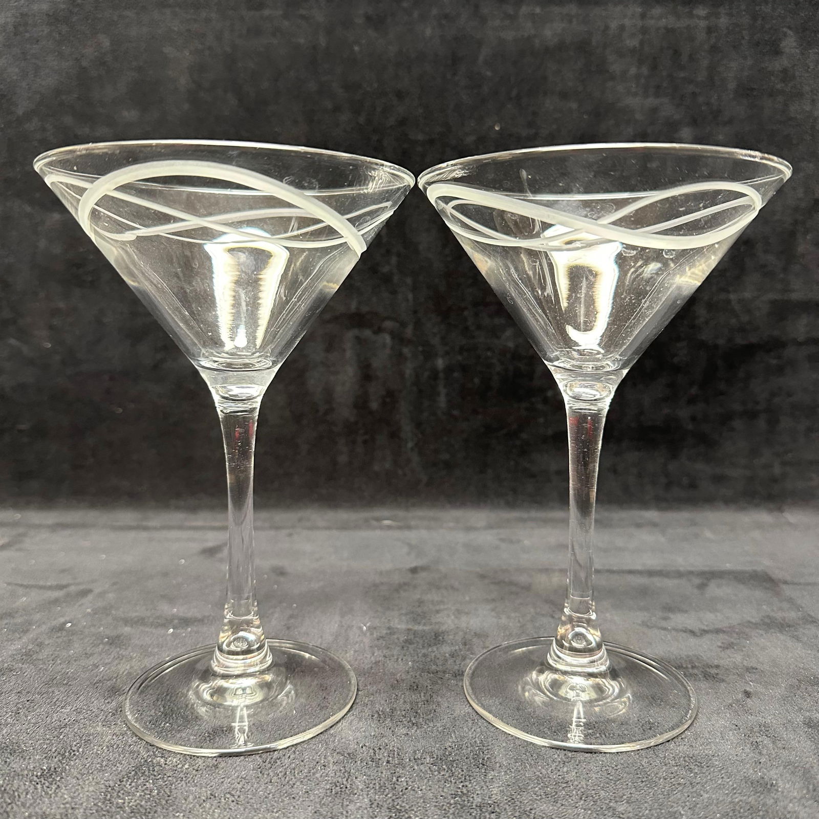 Pair of Clear Martini Glasses with Frosted Swirl Rim Decoration: Matching pair of clear stemmed martini glasses featuring conical bowls with applied frosted swirl decoration encircling the rim. Plain stems and round bases. Unmarked. These items are in good pre-owne